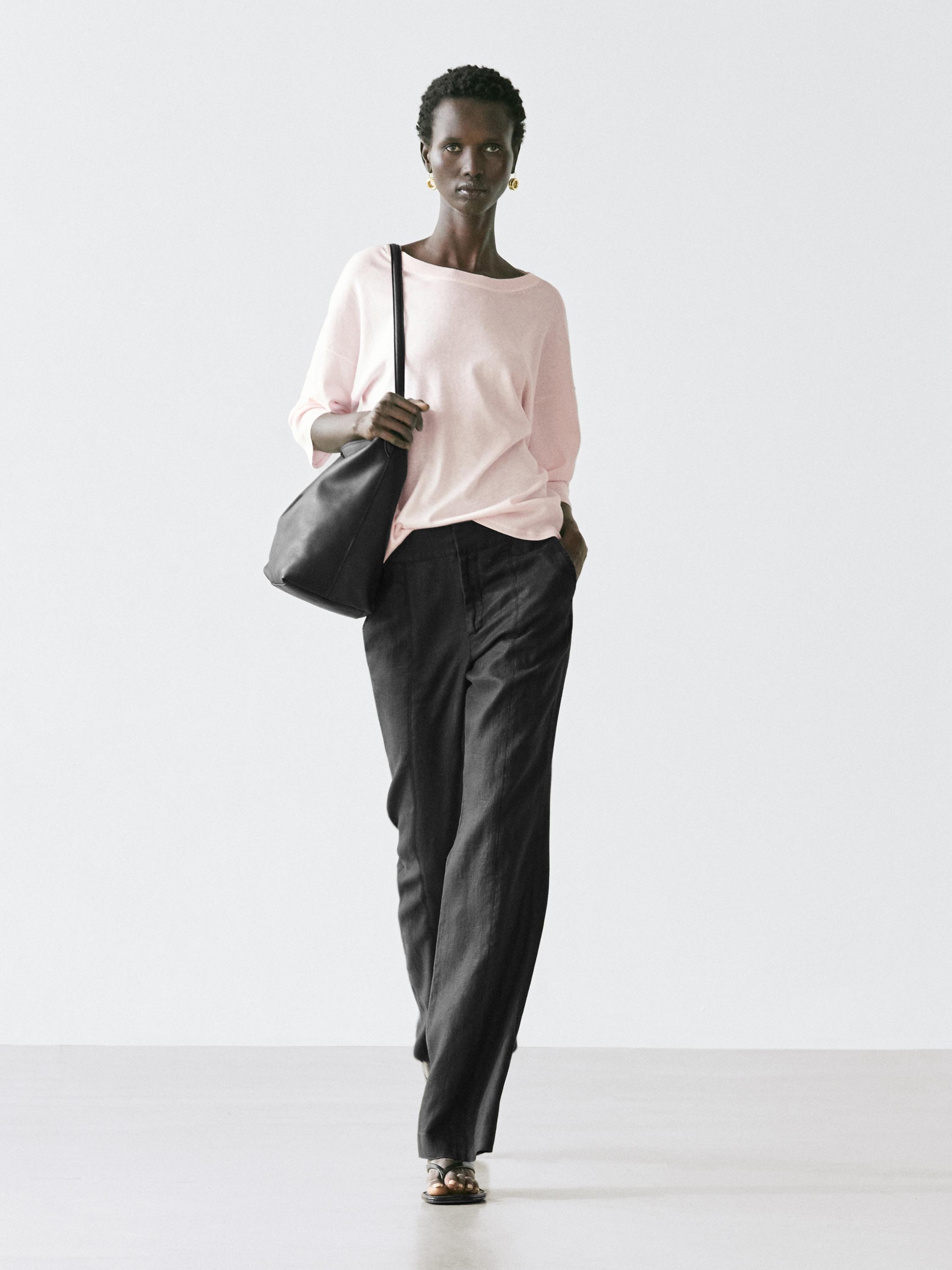 Conjunto de jersey rosa palo de manga corta y pantalones negros anchos.