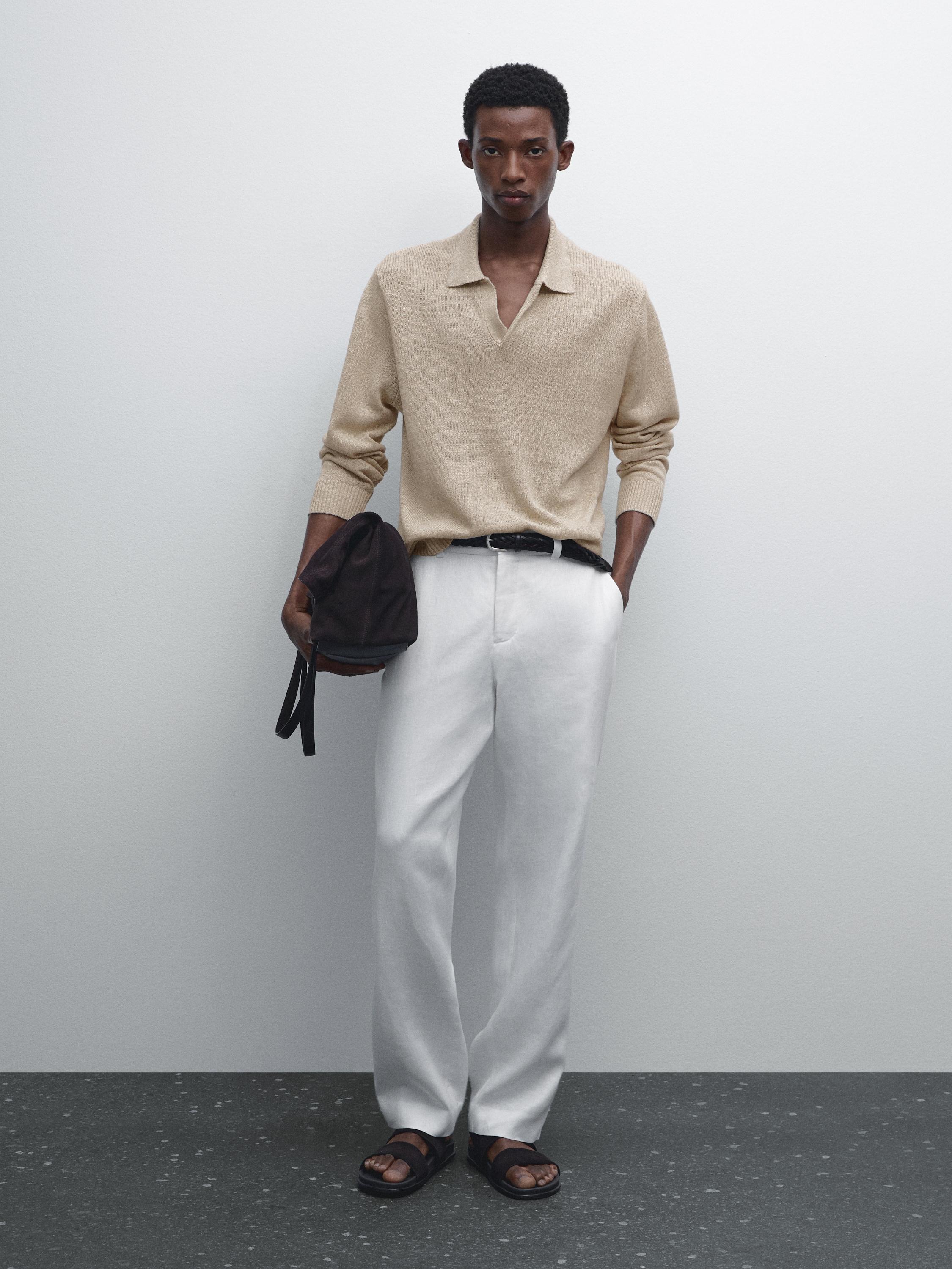 Ensemble pull beige à col ouvert et pantalon blanc droit.