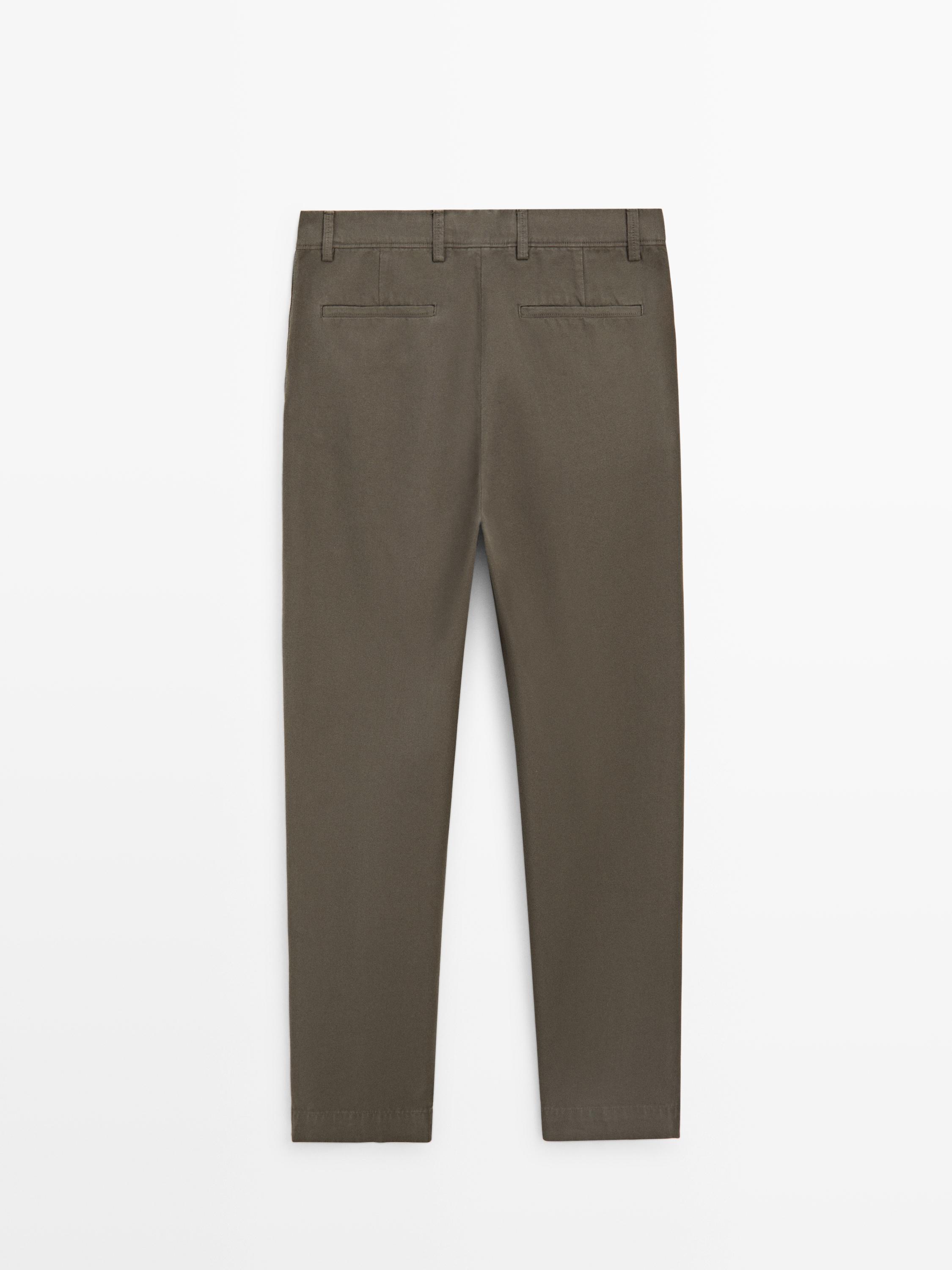 Vista posterior de pantalón verde tapered fit con bolsillos traseros.