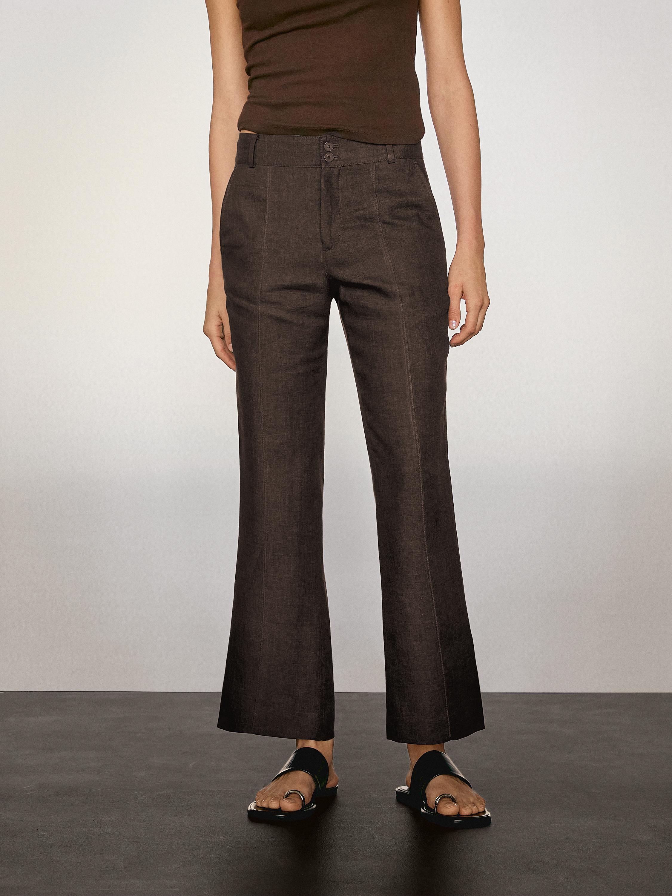 Ensemble composé d'un pantalon marron avec des poches latérales et de sandales noires.