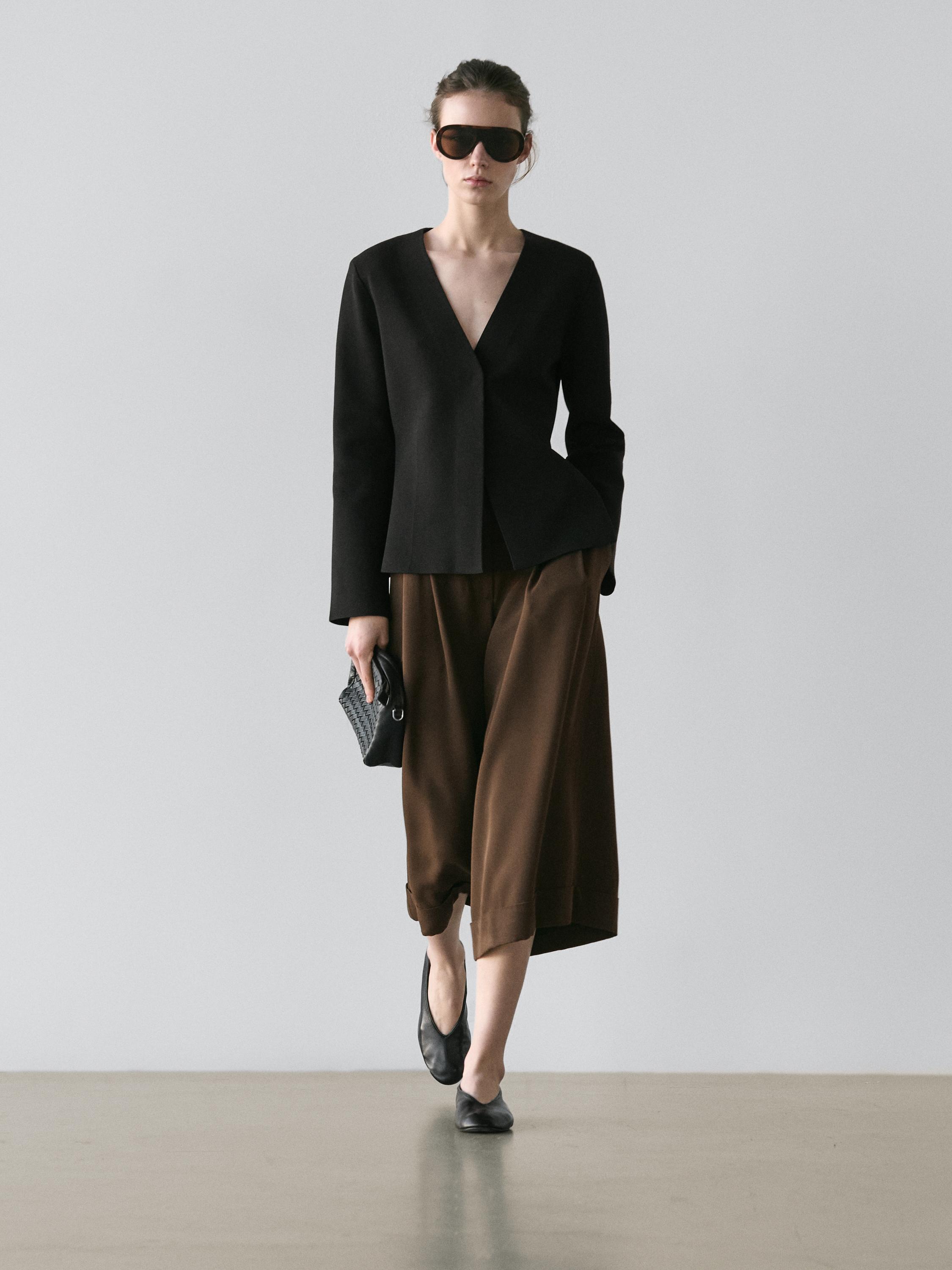 Ensemble de veste noire à col en V et bermuda long marron à revers.