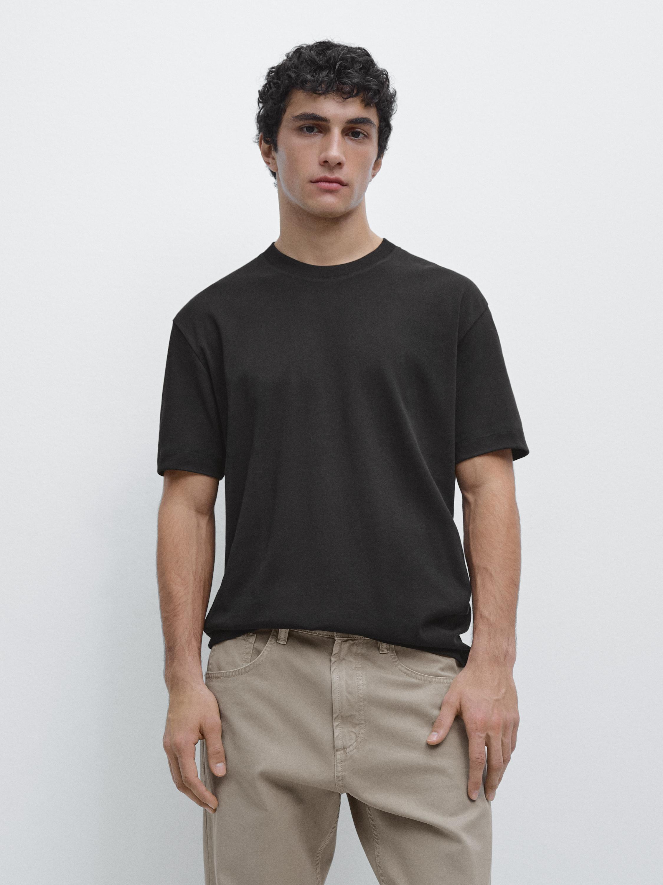 Set aus schwarzem Kurzarm-T-Shirt und beiger Hose mit Seitentaschen.