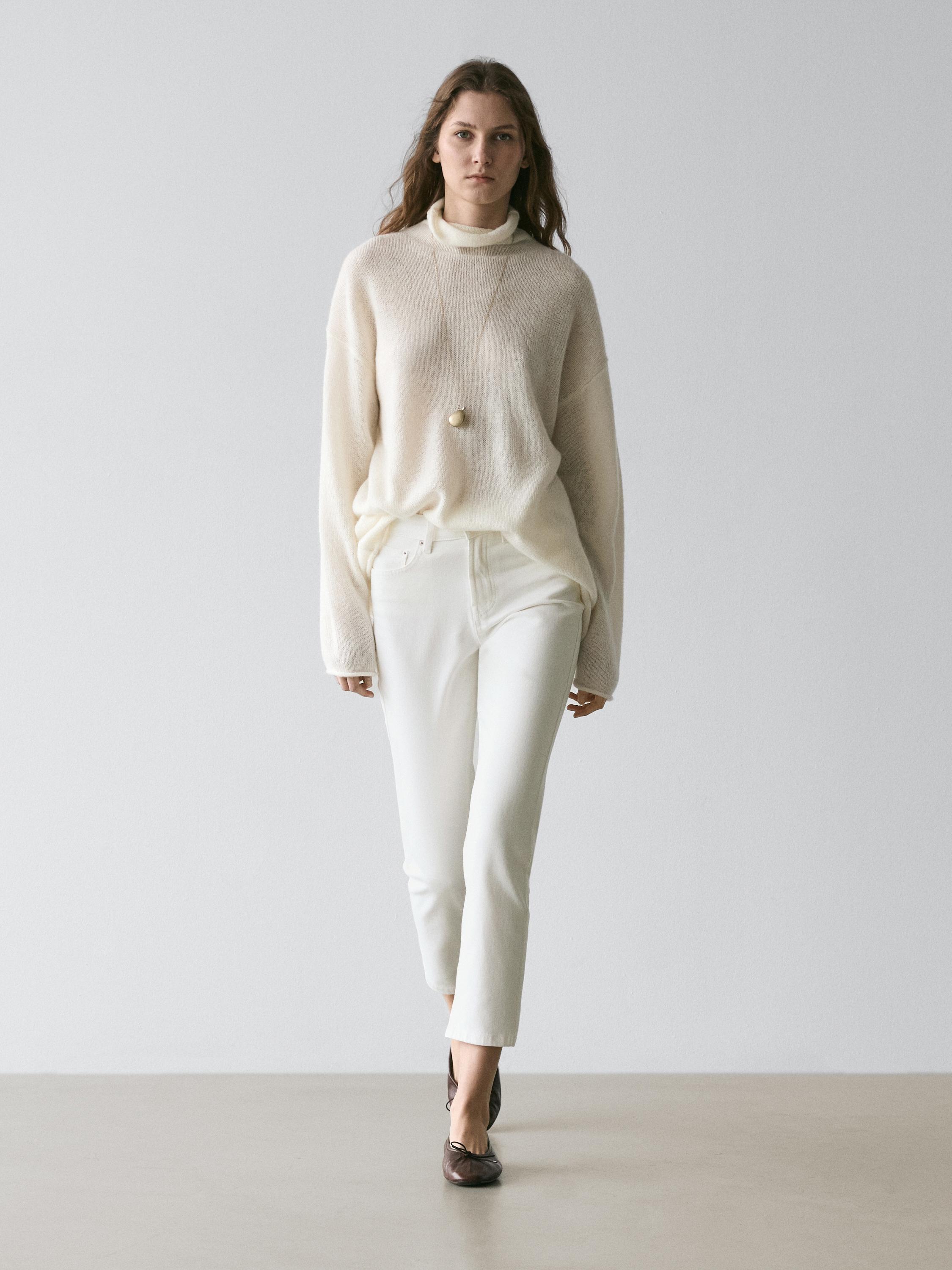 Beige turtleneck sweater and slim-fit cropped mid-rise jeans, with brown ballet flats.