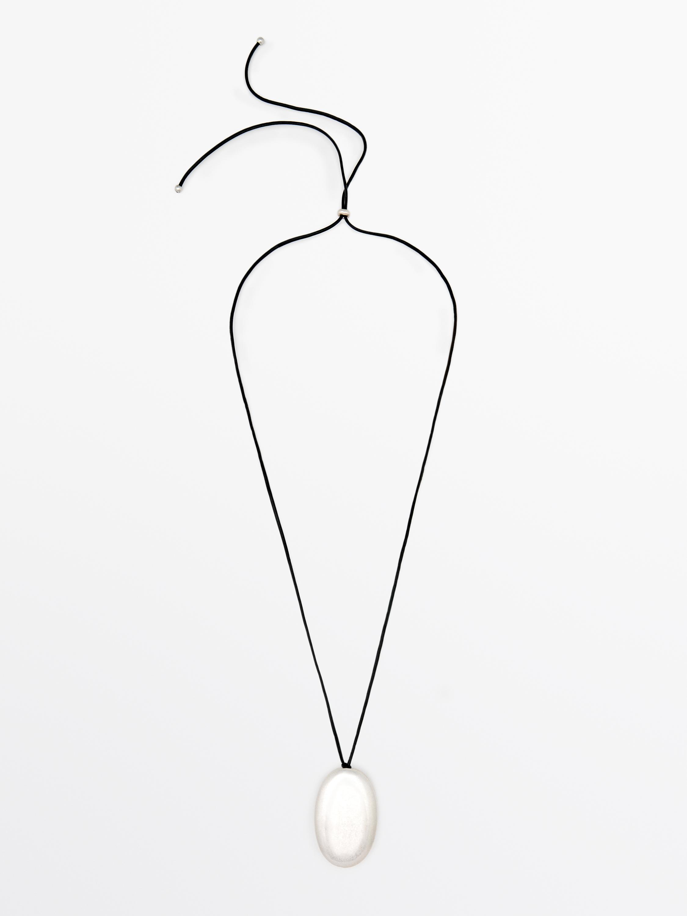 Black cord necklace with silver oval pendant.