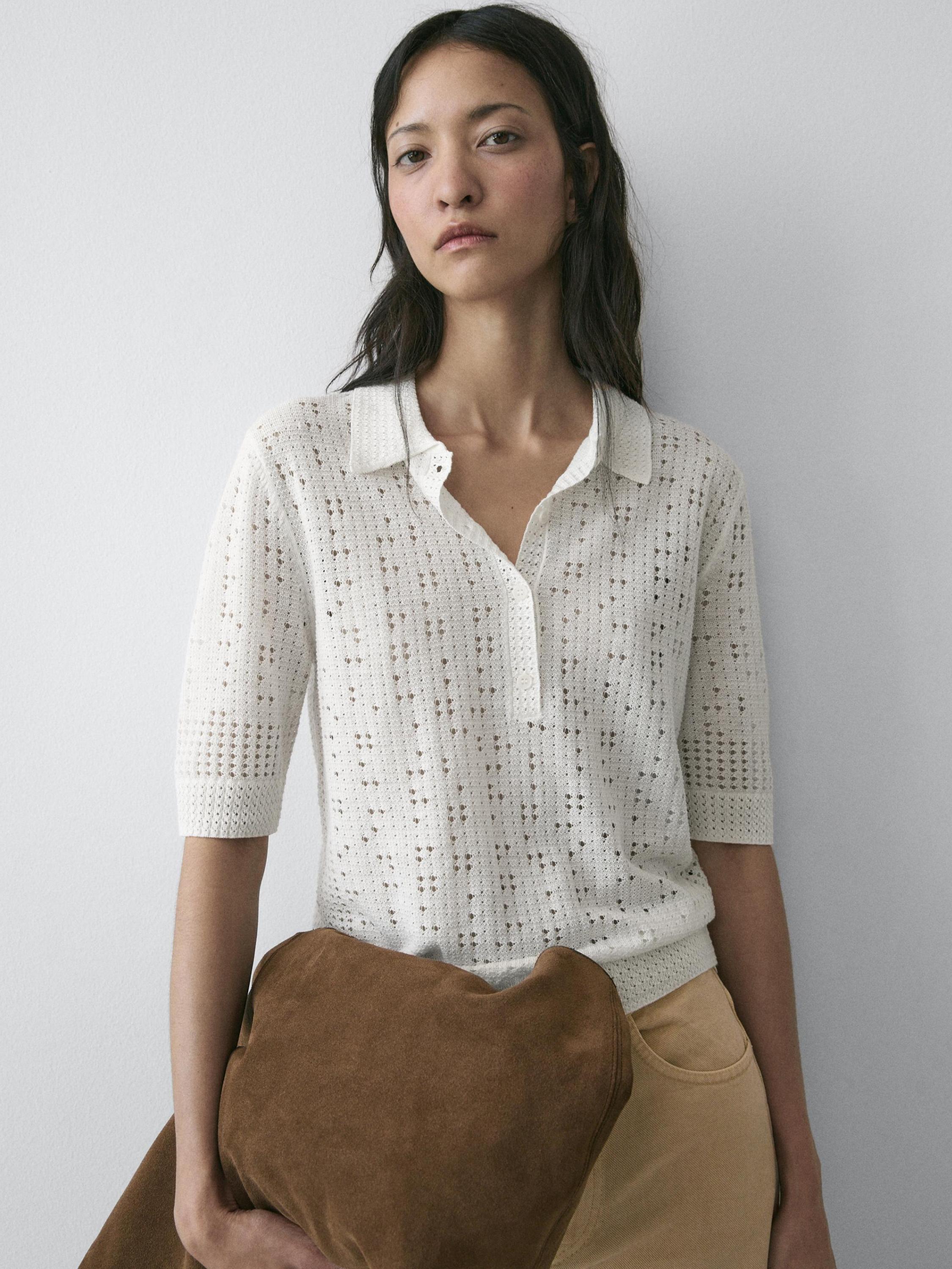 Cận cảnh áo jersey dệt kim màu kem cổ polo tay ngắn.