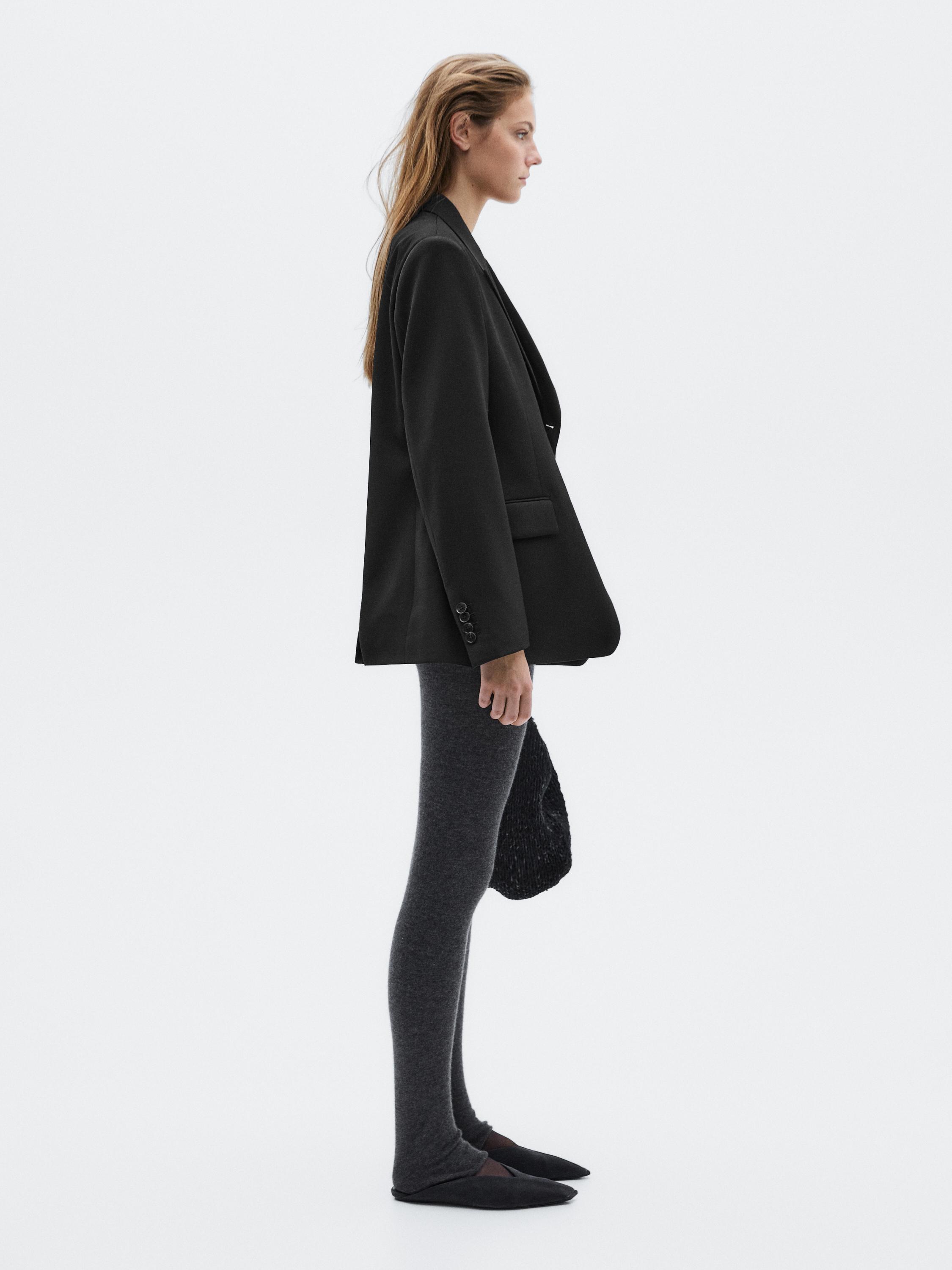 Black blazer set with side pockets and tight gray leggings.