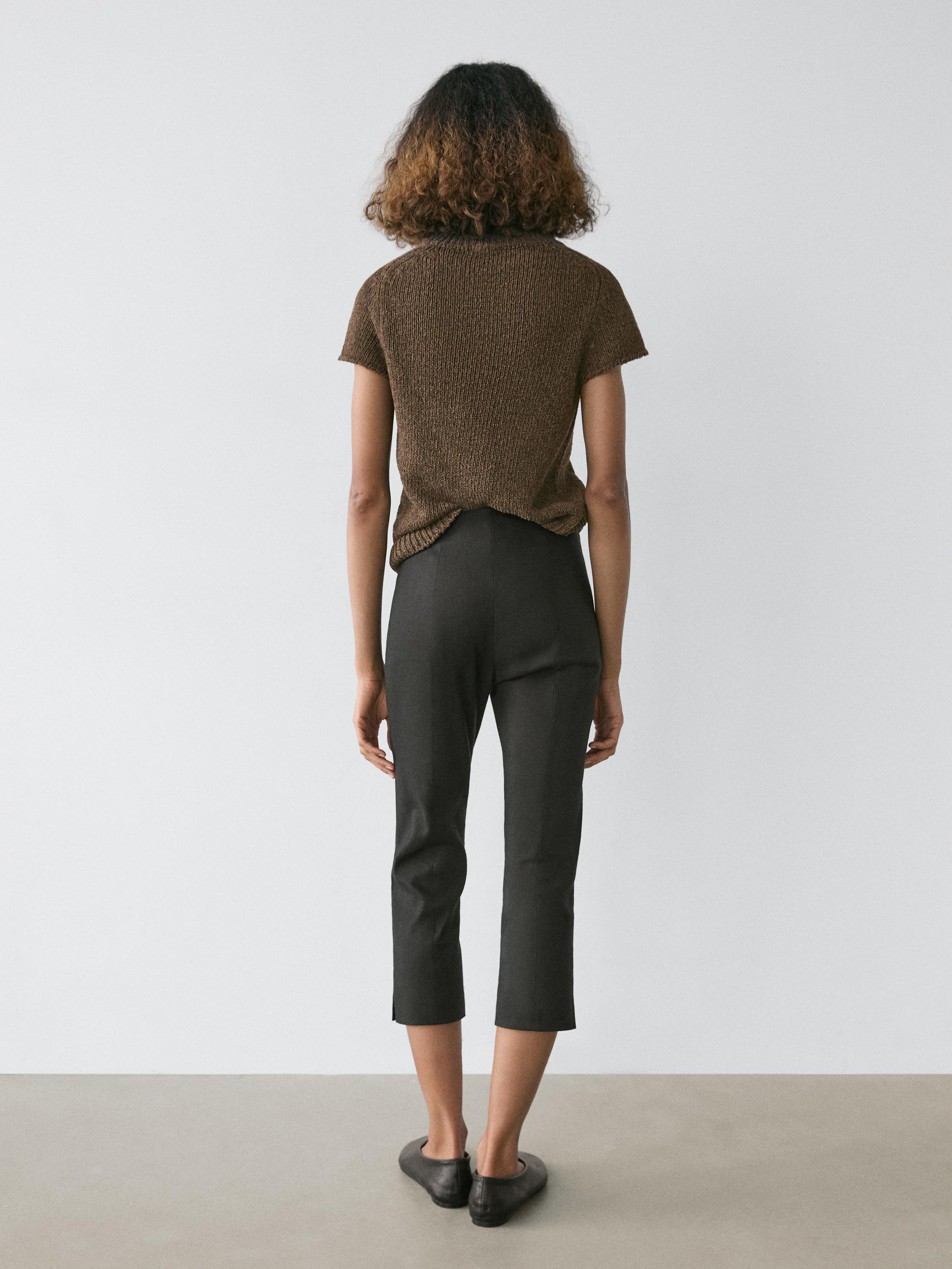 Conxunto de pantalón capri negro e camiseta marrón de manga curta, vista posterior.