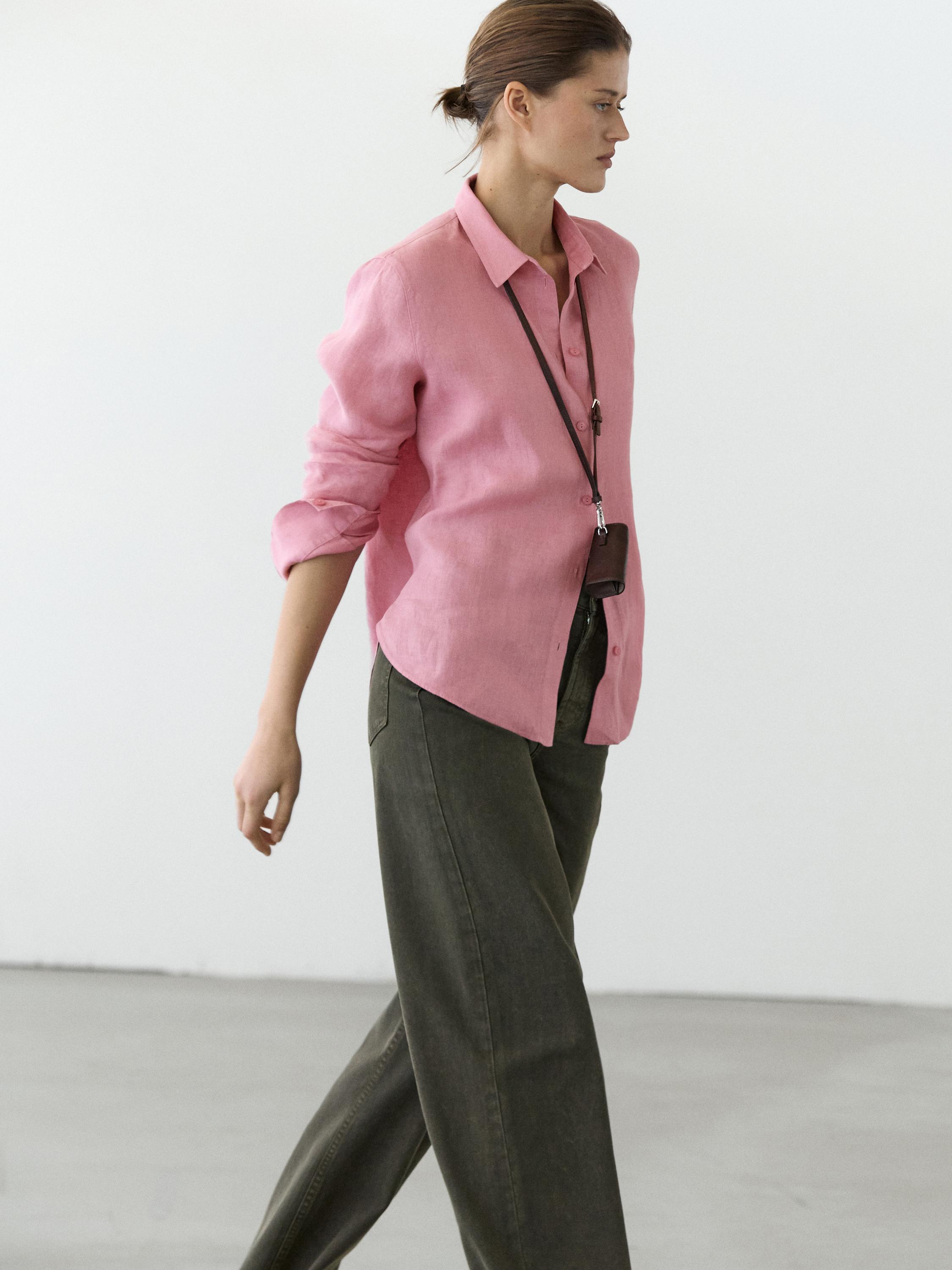 Ensemble chemise rose à manches longues et pantalon large vert foncé.