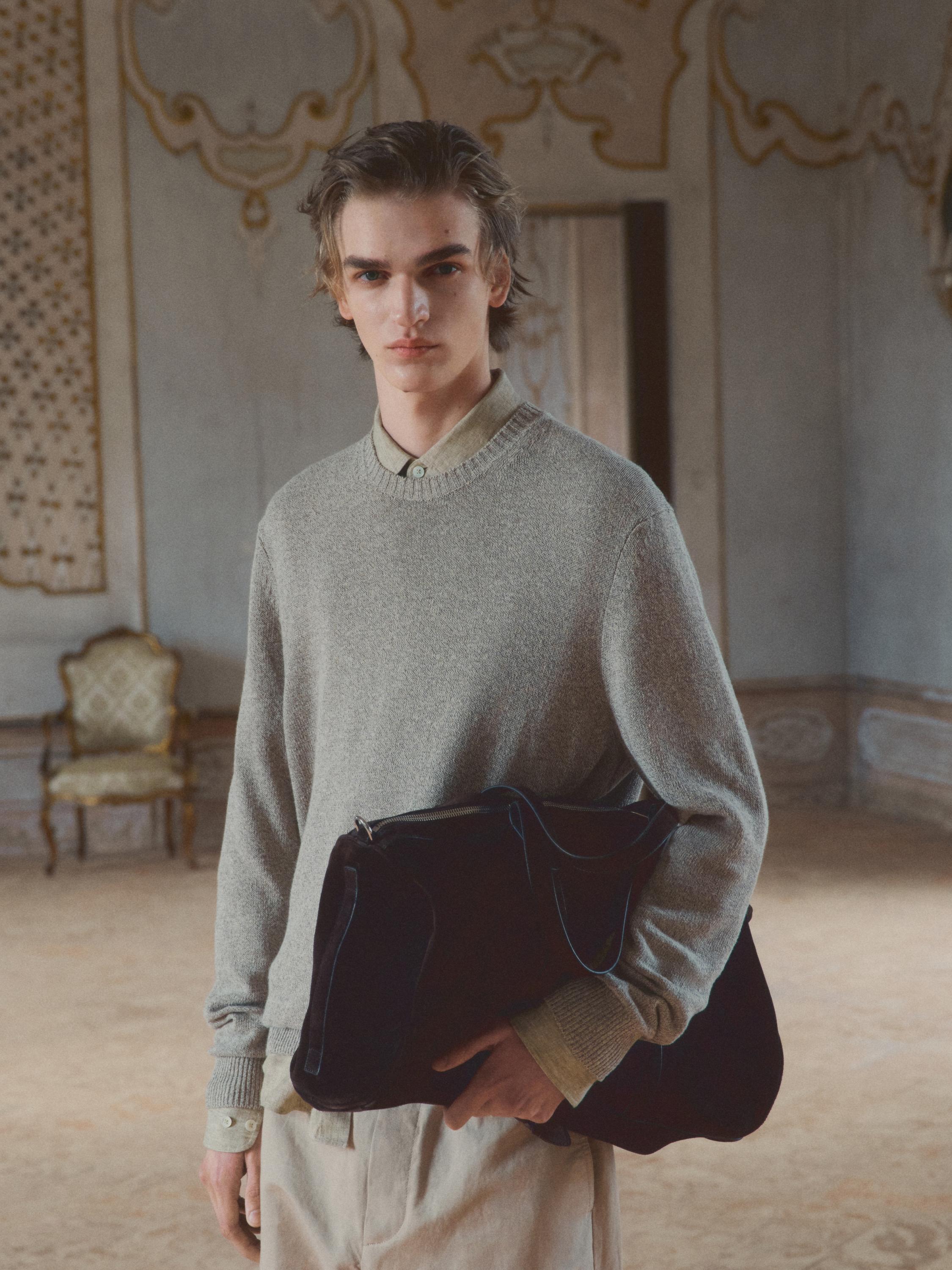 Conjunto de suéter beige de punto mouliné con cuello redondo y camisa debajo, pantalones claros.