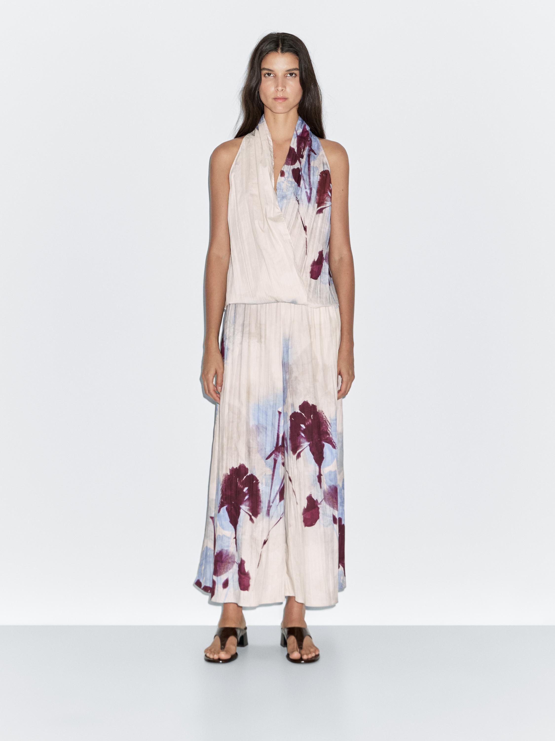 طقم توب بدون أكمام وبنطلون واسع بنقشة زهور باللون العنابي والأزرق على خلفية فاتحة.