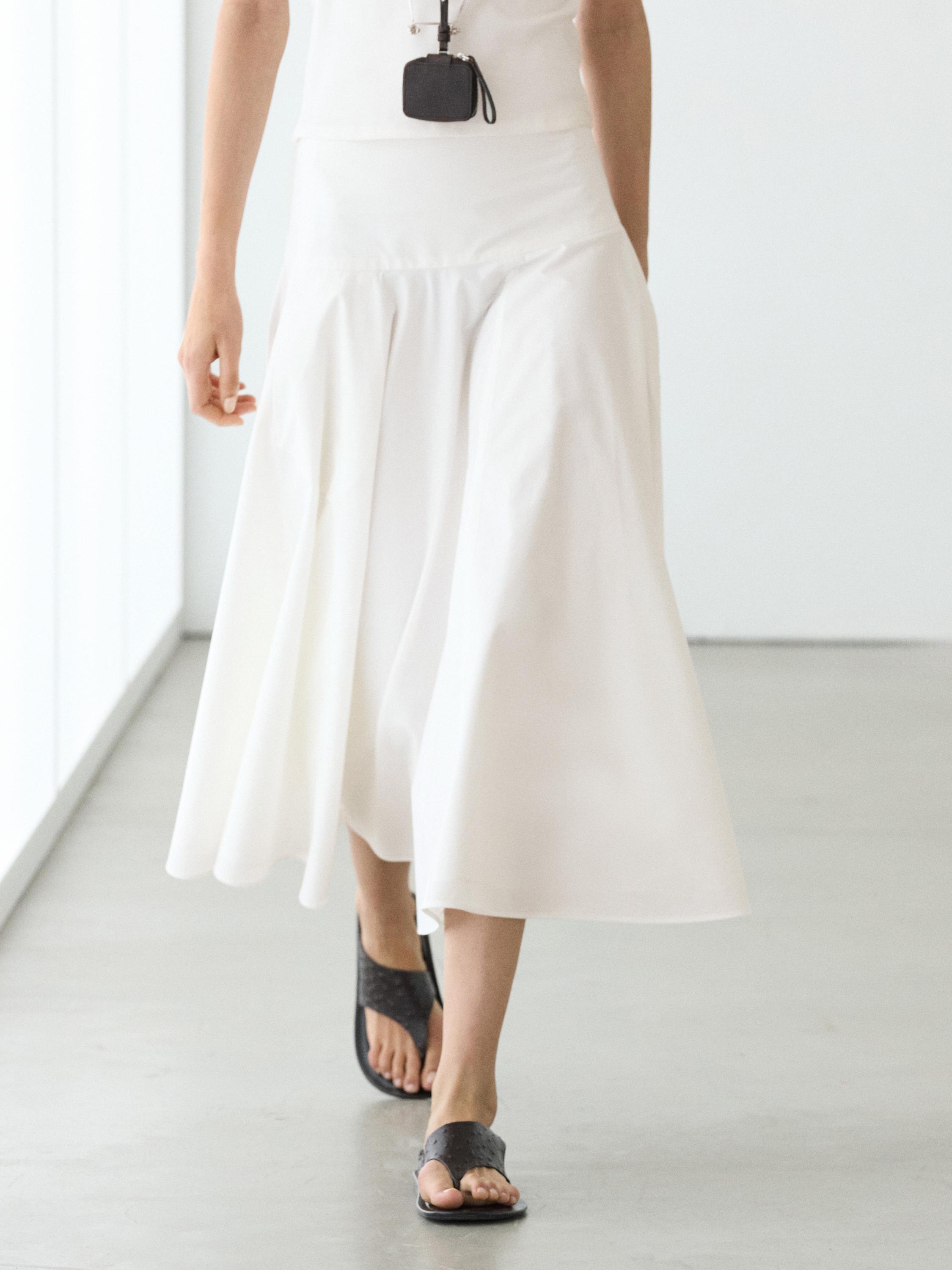 White midi skirt set with yoke and black sandals.