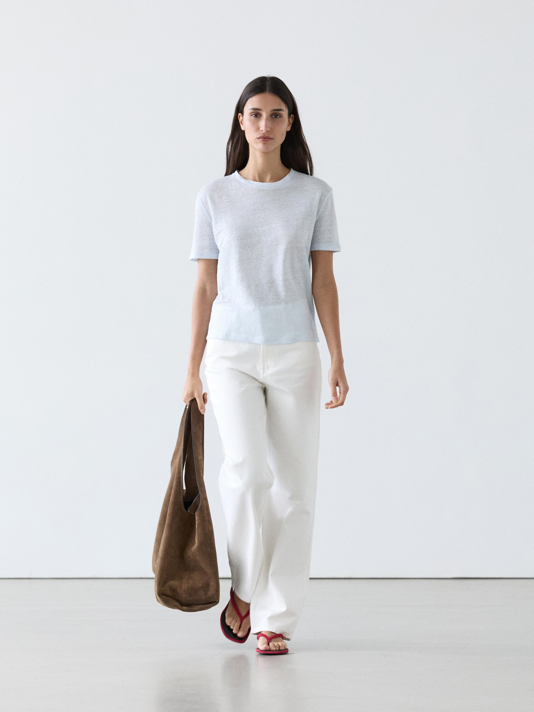 Ensemble t-shirt bleu ciel à manches courtes et pantalon blanc ample.