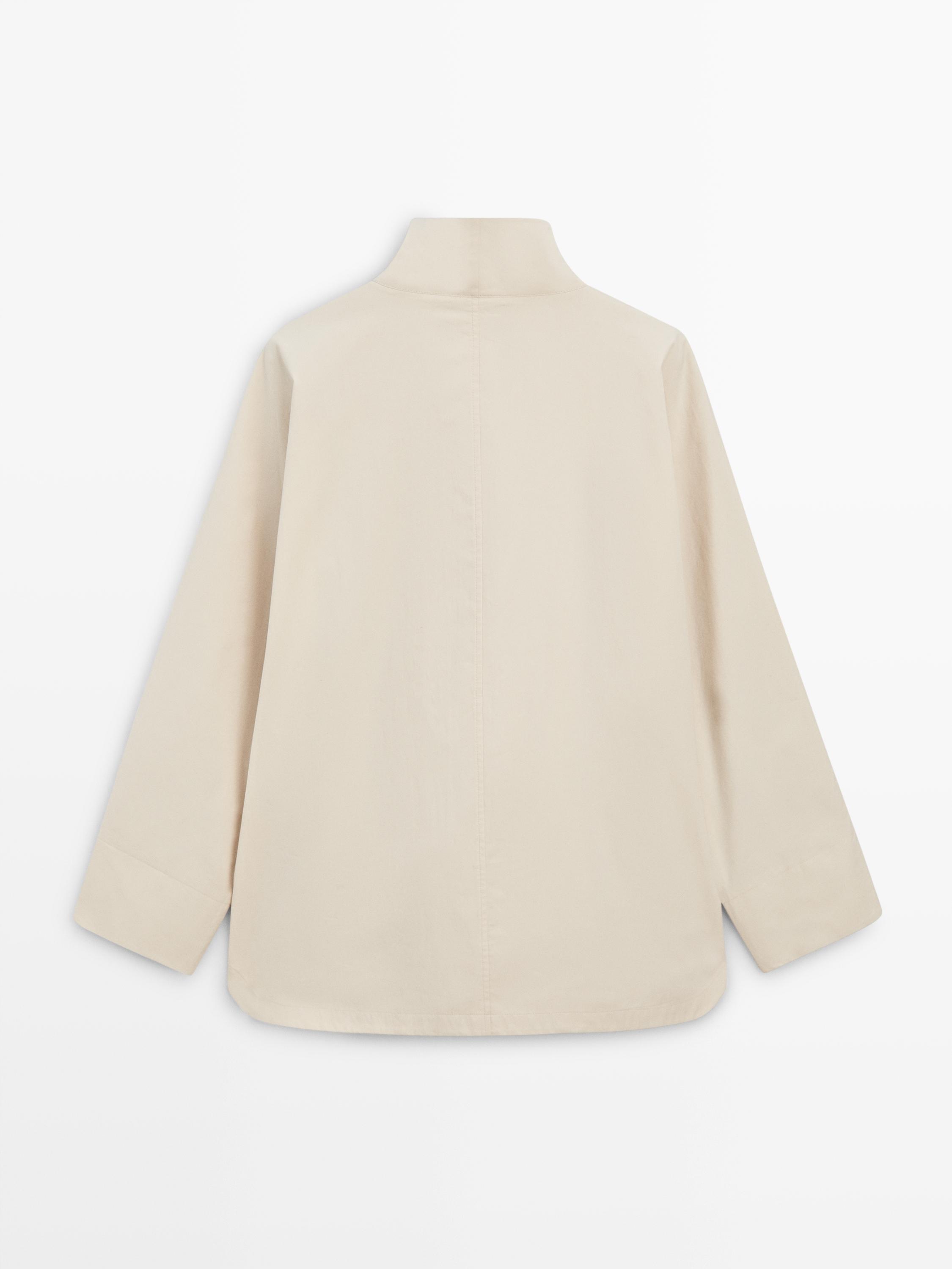 Вид сзади на куртку цвета экрю с воротником-стойкой и длинными рукавами.
