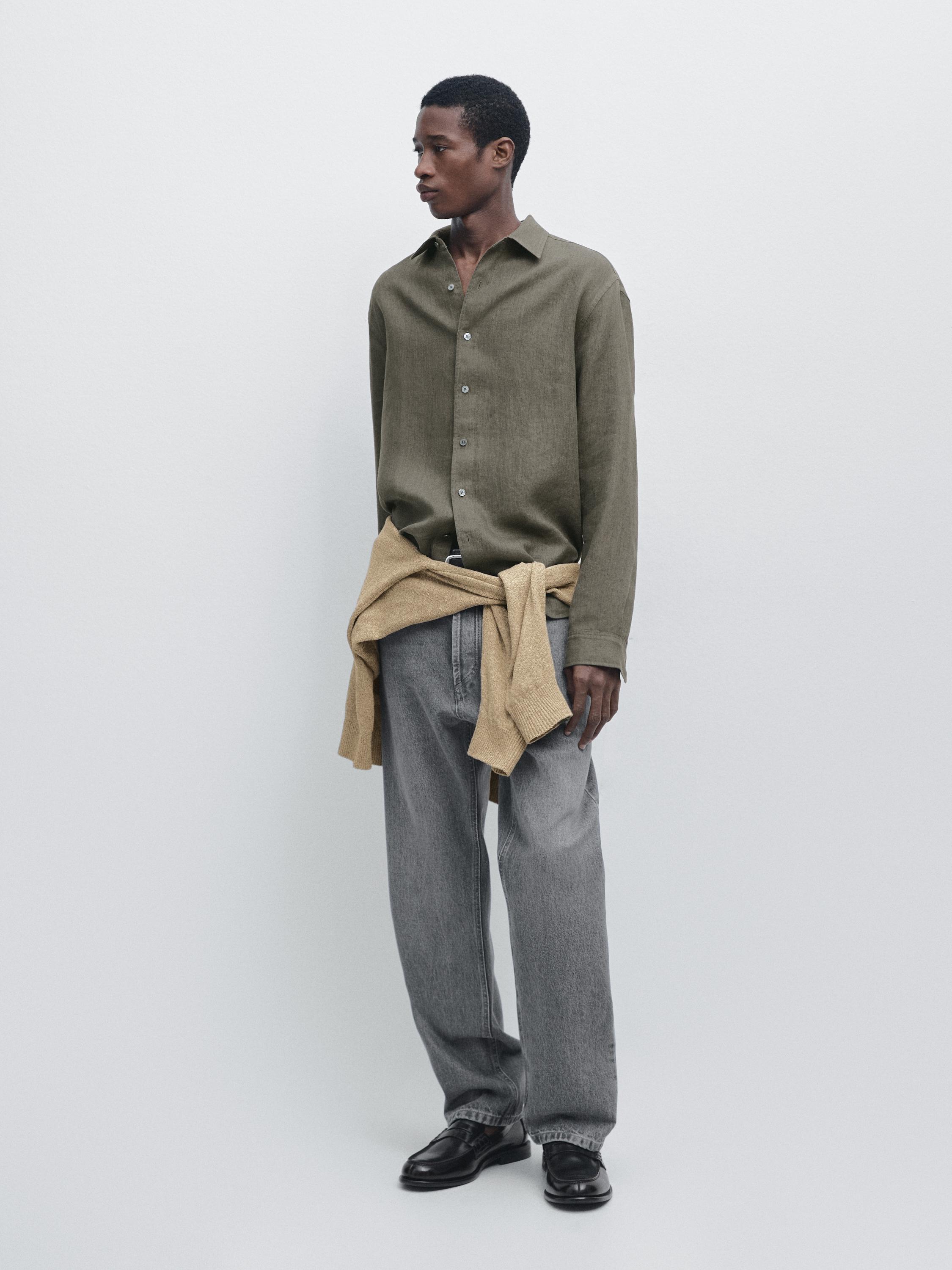 Long-sleeved green shirt, wide gray pants, and beige sweater tied at the waist.