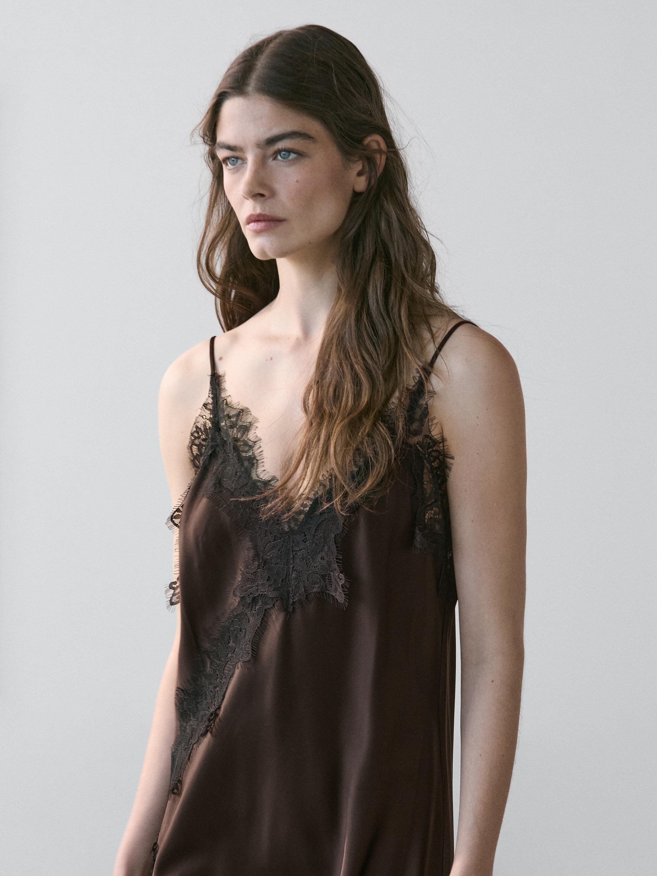 Plan moyen de robe nuisette couleur chocolat à fines bretelles et détails en dentelle noire sur le décolleté et les côtés.