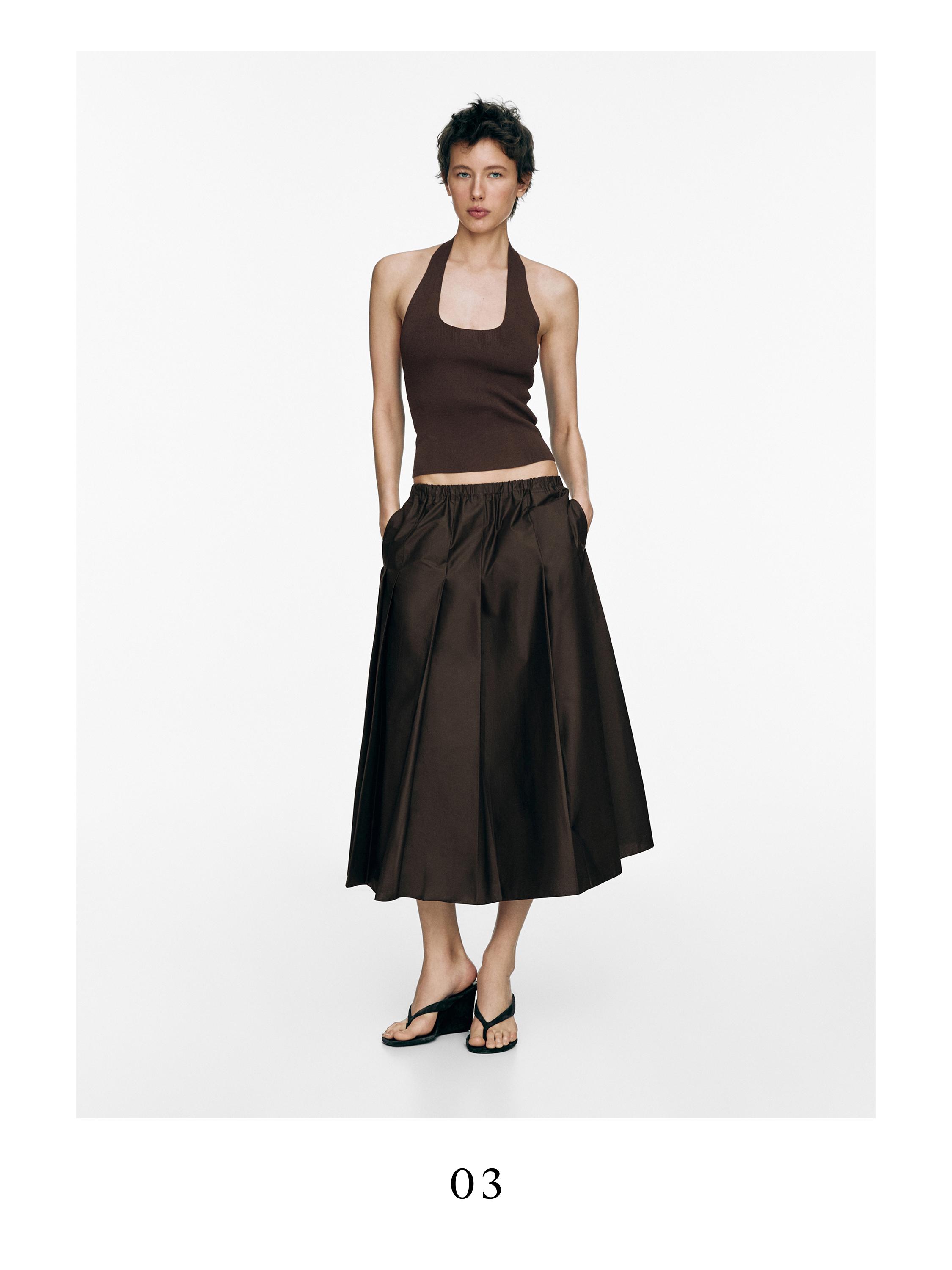 Σετ από καφέ αμάνικο τοπ και σοκολατί μίντι φούστα με πιέτες και πλαϊνές τσέπες.