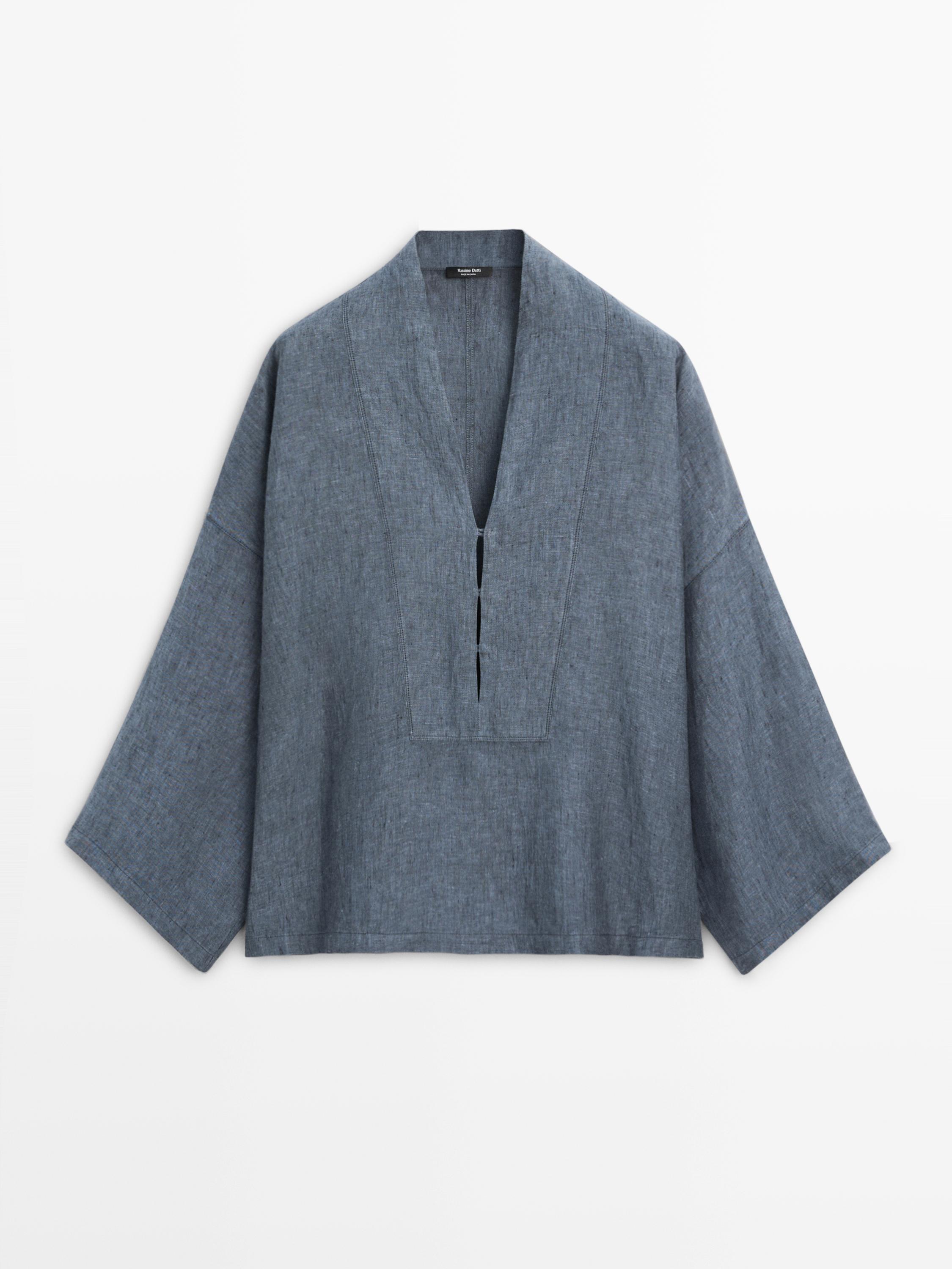 Vue frontale d'une chemise indigo avec un col en V profond et des manches larges.