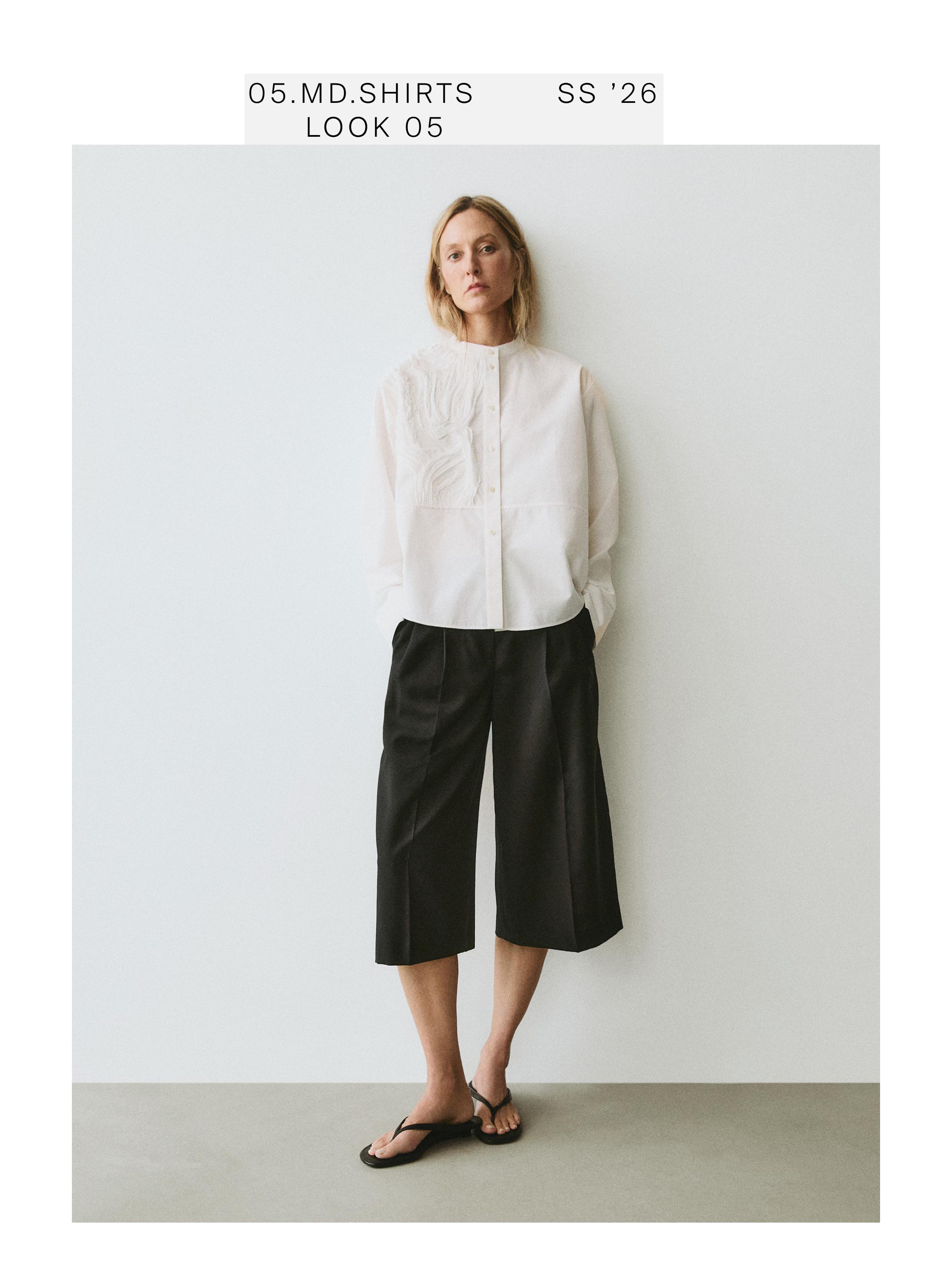 White shirt and black culotte pants set with chest embroidery. Visible text: "05.MD.SHIRTS SS '26 LOOK 05".