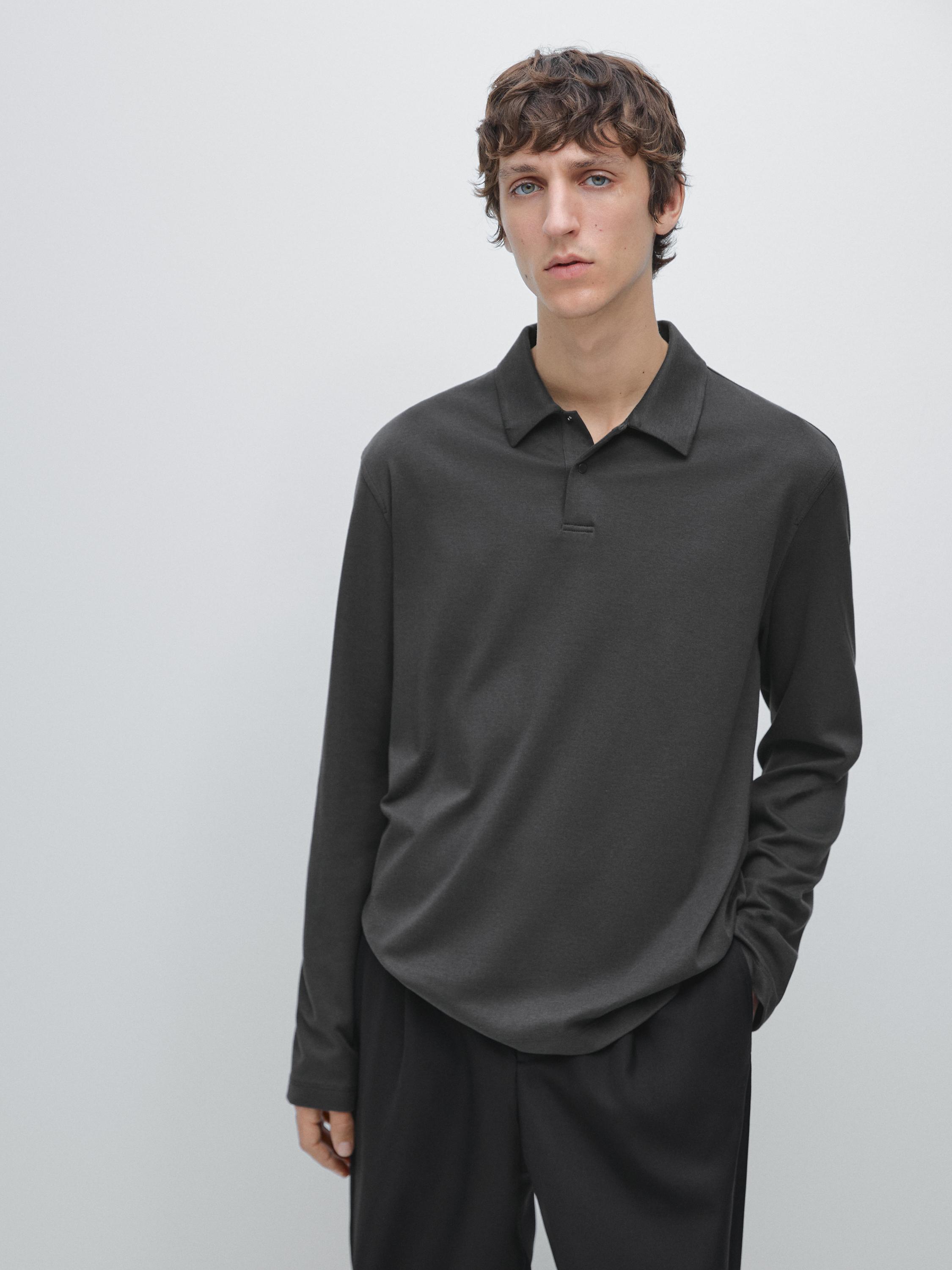 طقم بولو رمادي بأكمام طويلة مع ياقة كلاسيكية وبنطلون أسود.