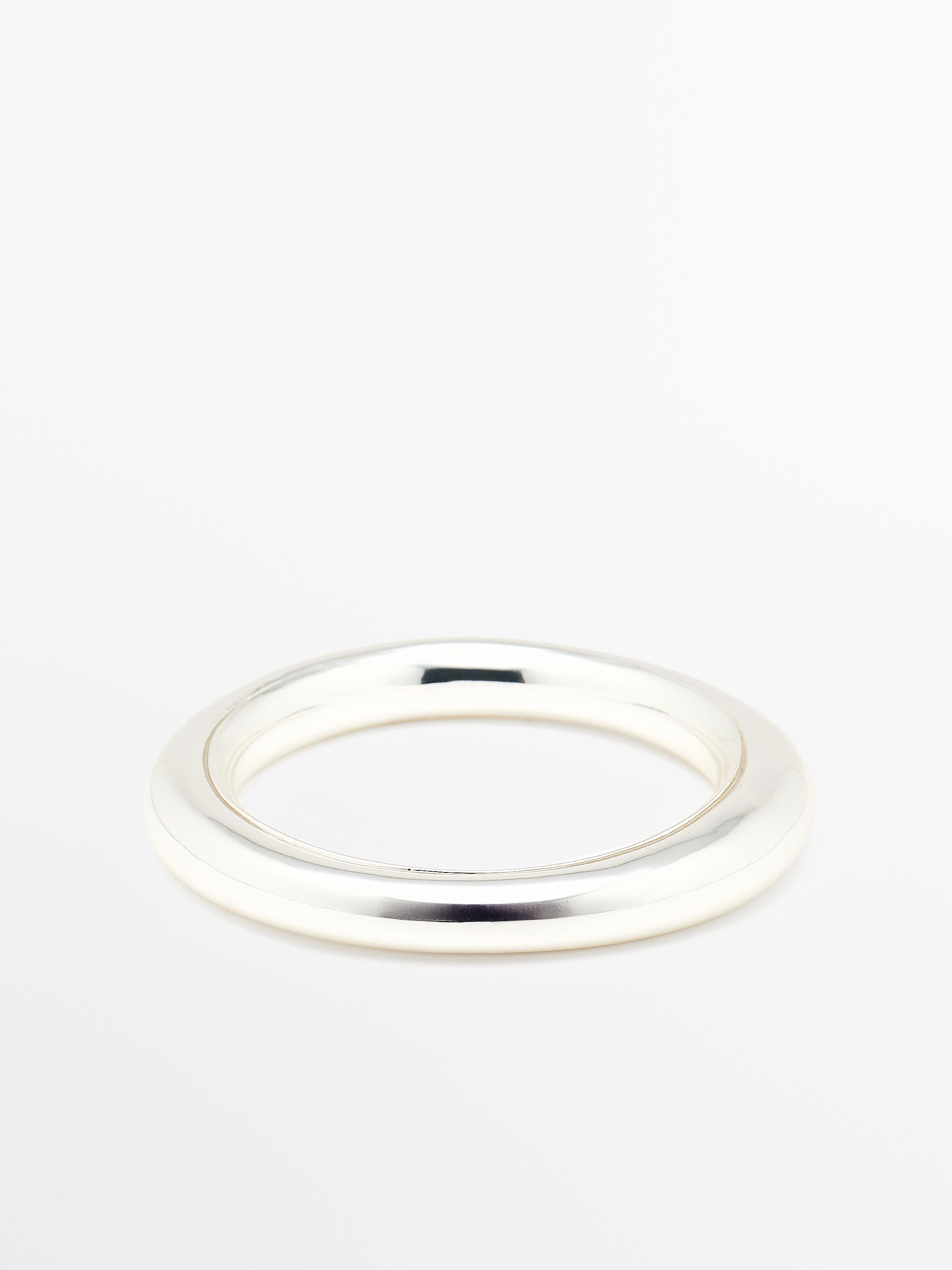 Vooraanzicht van een zilverkleurige stijve armband met een glad ontwerp en een ronde vorm.