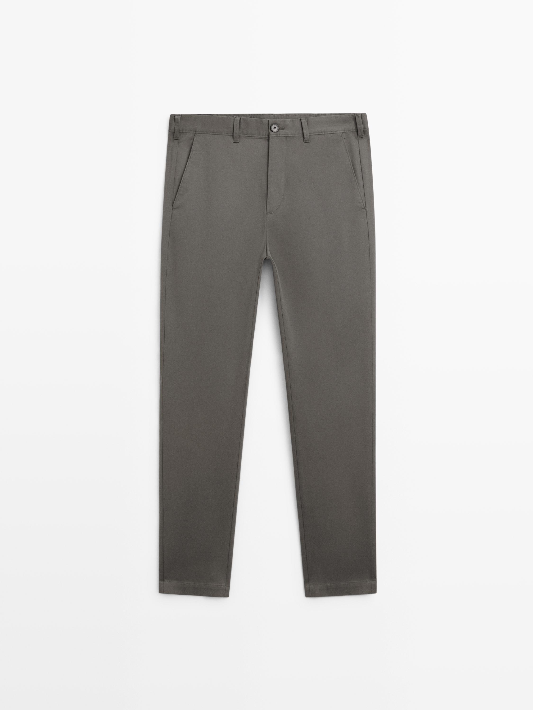 Front view of gray slim-fit pants with side pockets and button closure.