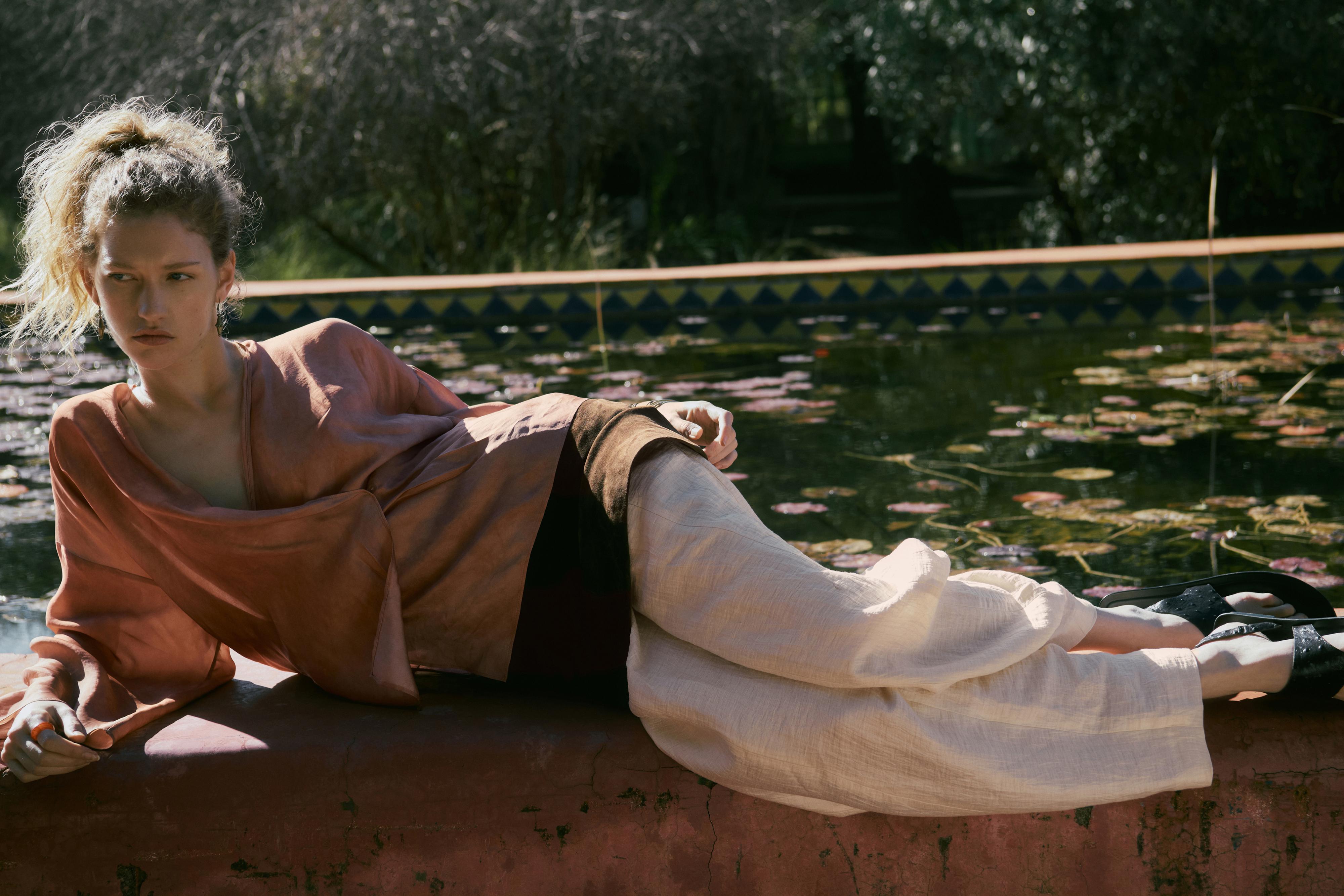 Ensemble rose composé d'un chemisier à manches longues et d'un pantalon beige ample.