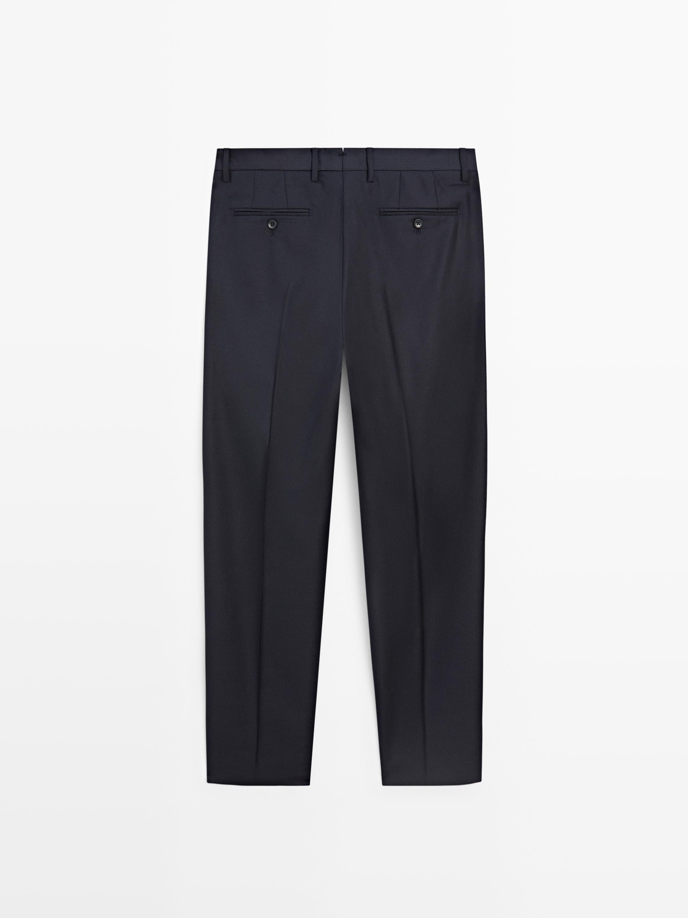 Πίσω όψη ναυτικού μπλε παντελονιού κοστουμιού με πίσω τσέπες με κουμπί και θηλιές ζώνης.