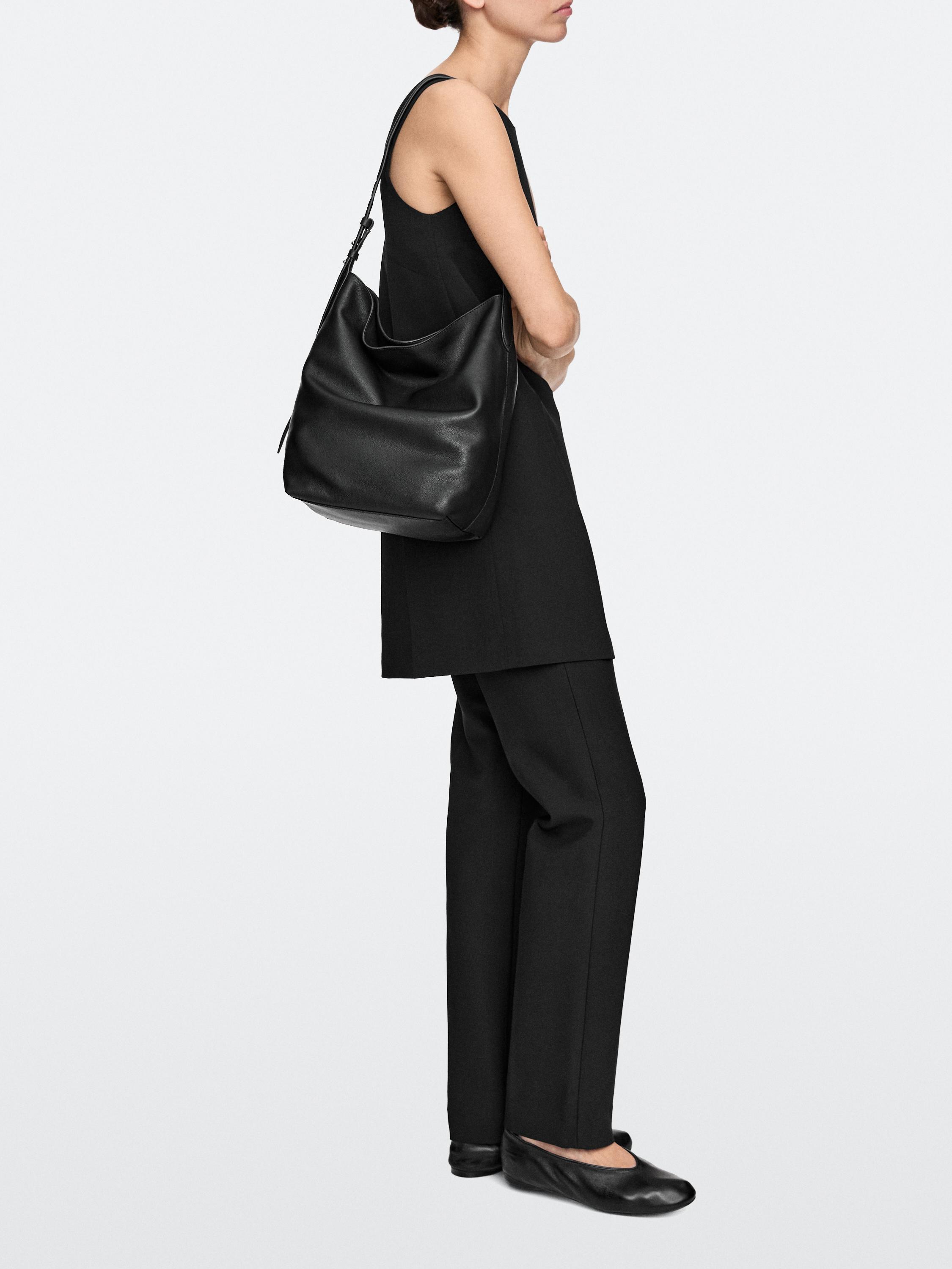Black large shoulder bag set, black sleeveless dress, and black straight-leg pants.