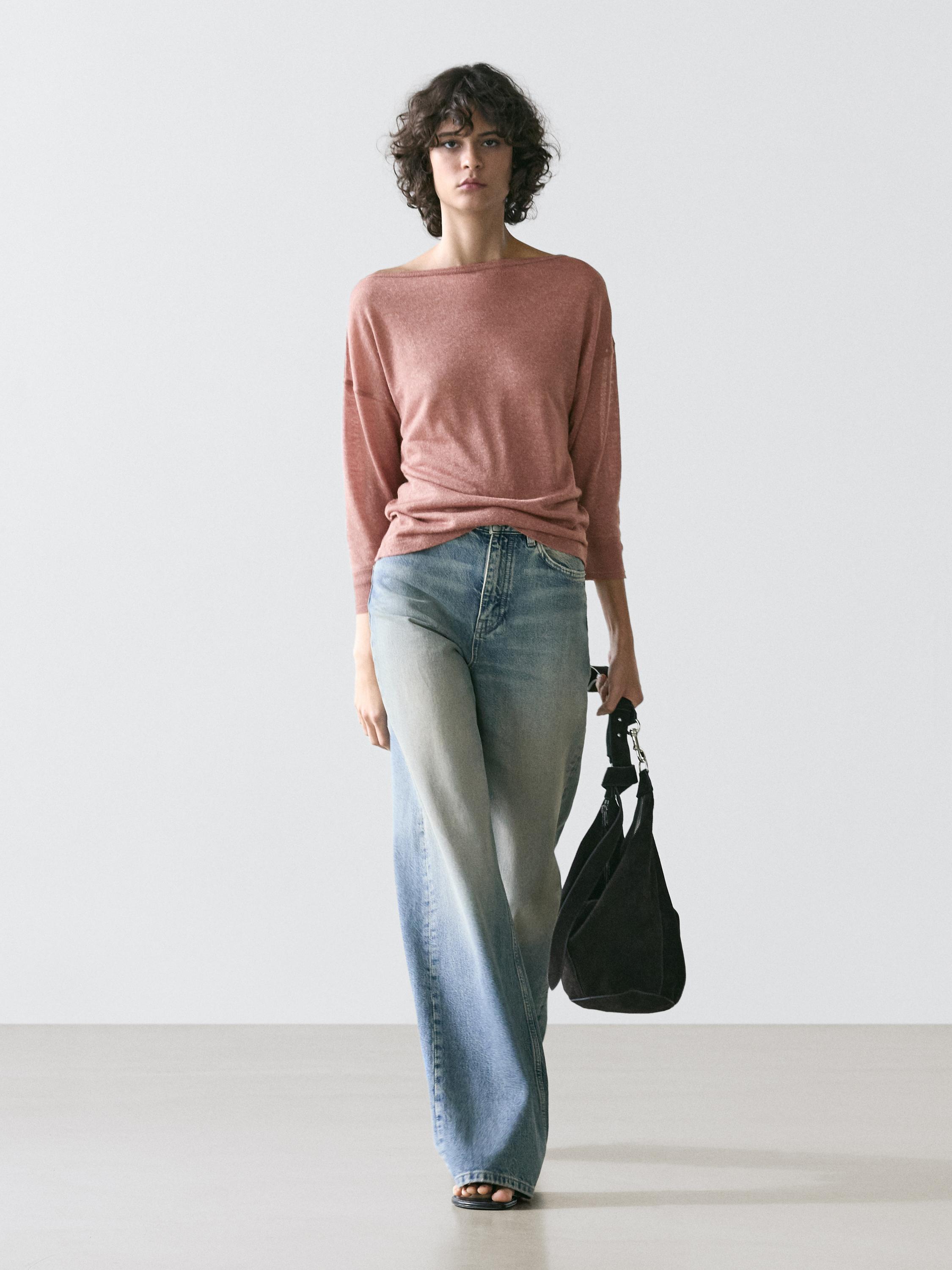 Conjunto de camiseta roja de manga larga y jeans anchos azules.