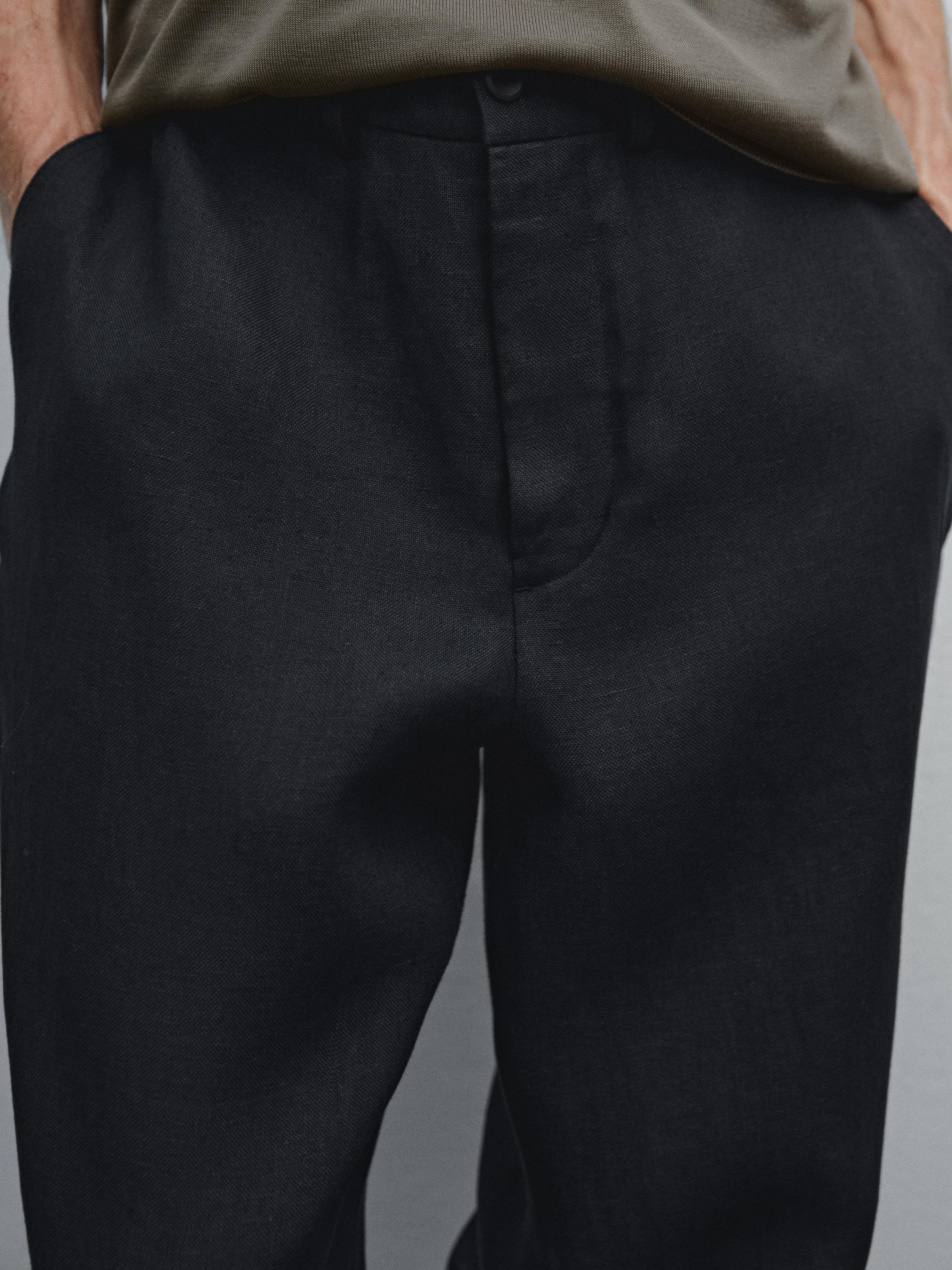 Gros plan d'un pantalon noir avec des poches latérales.