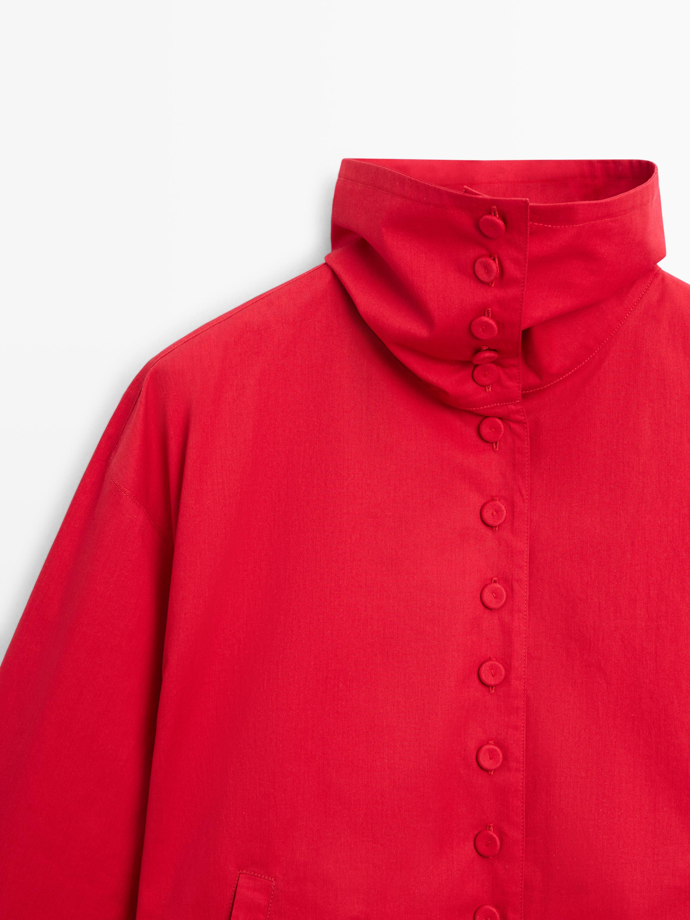 Λεπτομέρεια από ψηλό γιακά και κουμπιά σε έντονο κόκκινο σακάκι με πλαϊνές τσέπες.