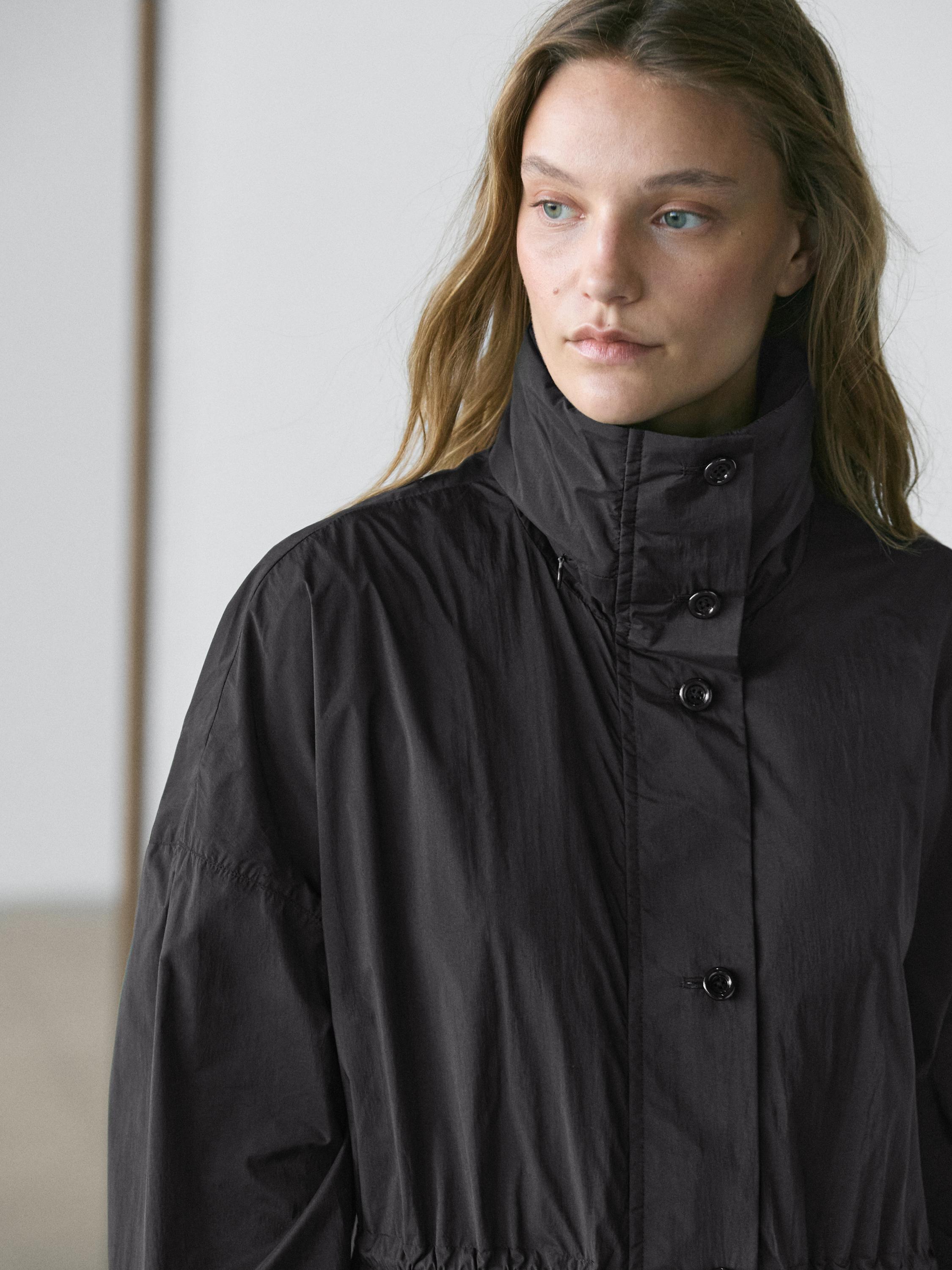 Medium shot of a dark blue parka with a high collar and front buttons.