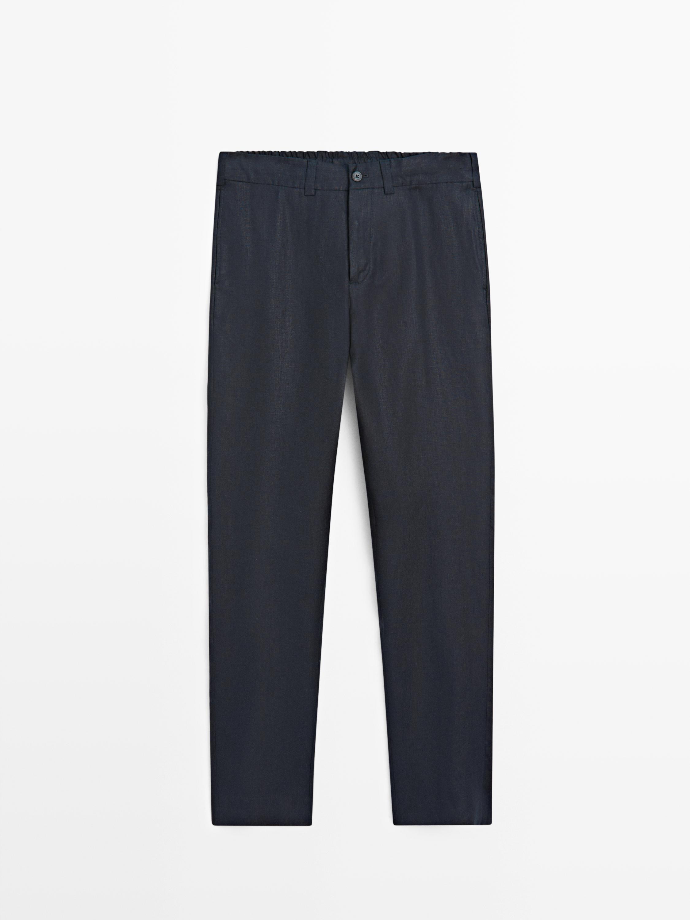 Front view of deep blue pants with elastic waistband, front button, and side pockets.