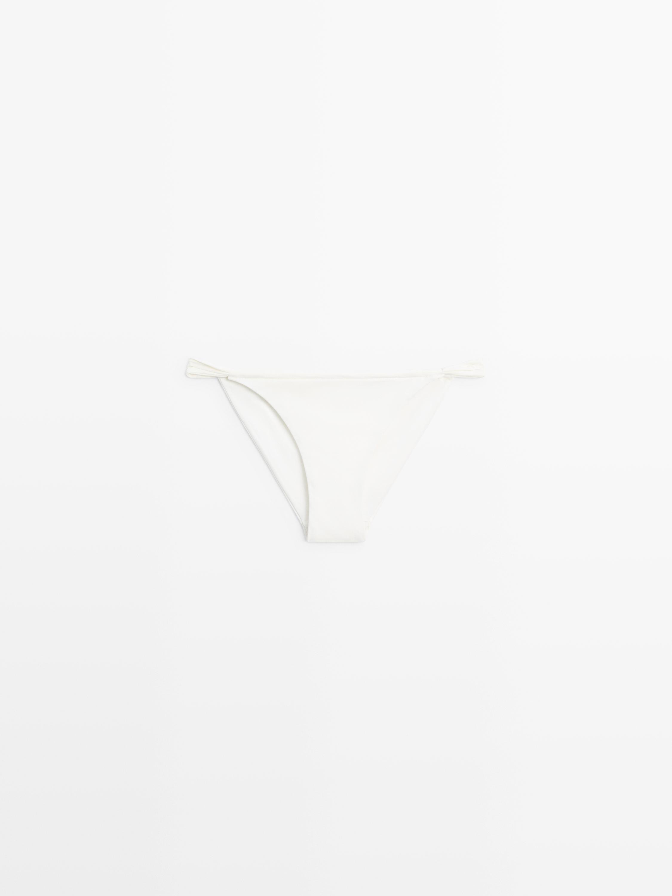 Vista frontal de braguita de bikini blanco roto con lazos laterales.