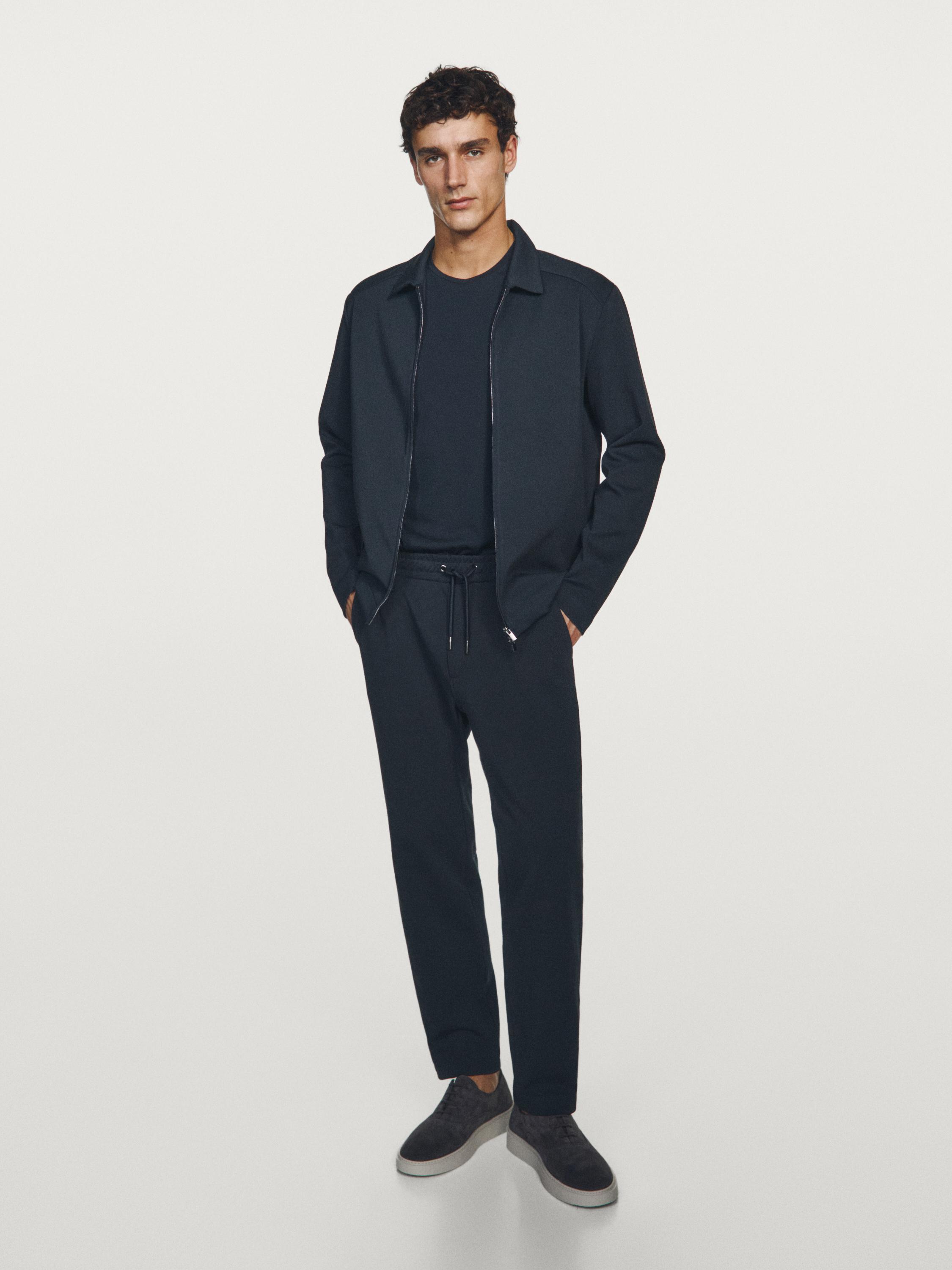 طقم جاكيت بسحاب وبنطلون مستقيم كحلي، مع جيوب جانبية ورباط قابل للتعديل.