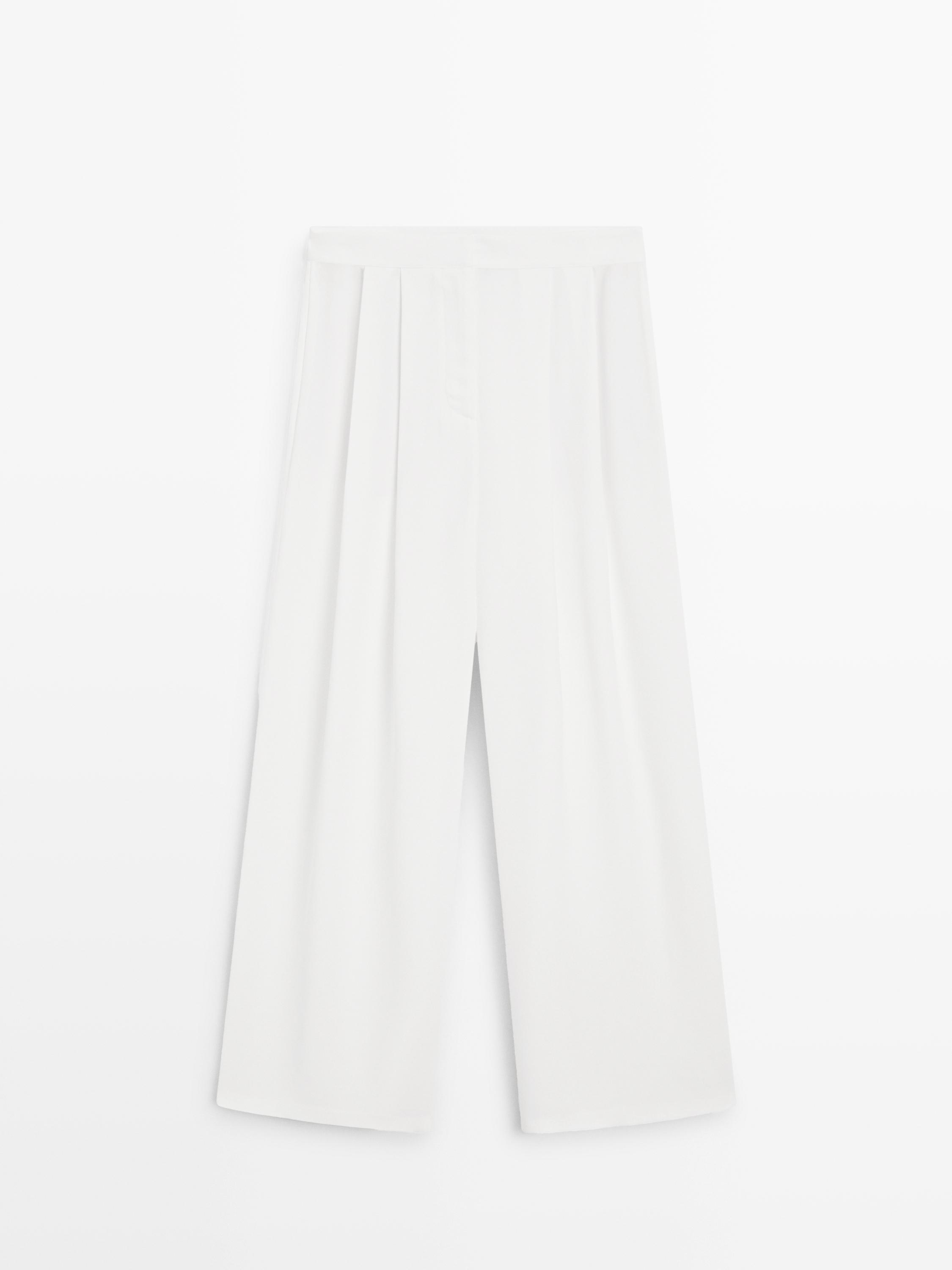 Tampilan depan celana putih gading dengan lipatan depan dan potongan lebar.