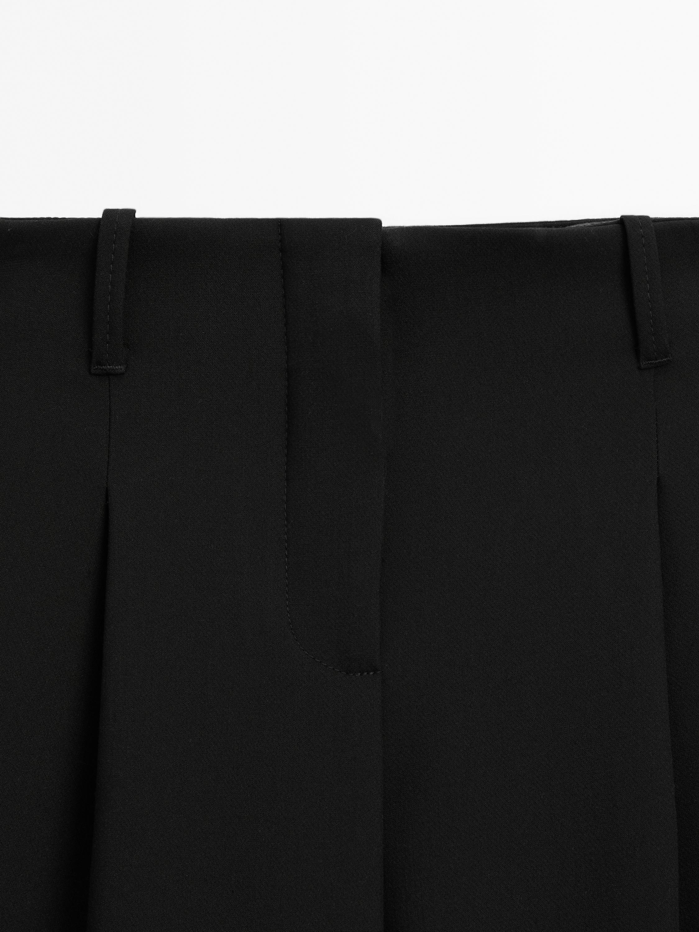 Pantalón tiro medio fluído detalle fibelas