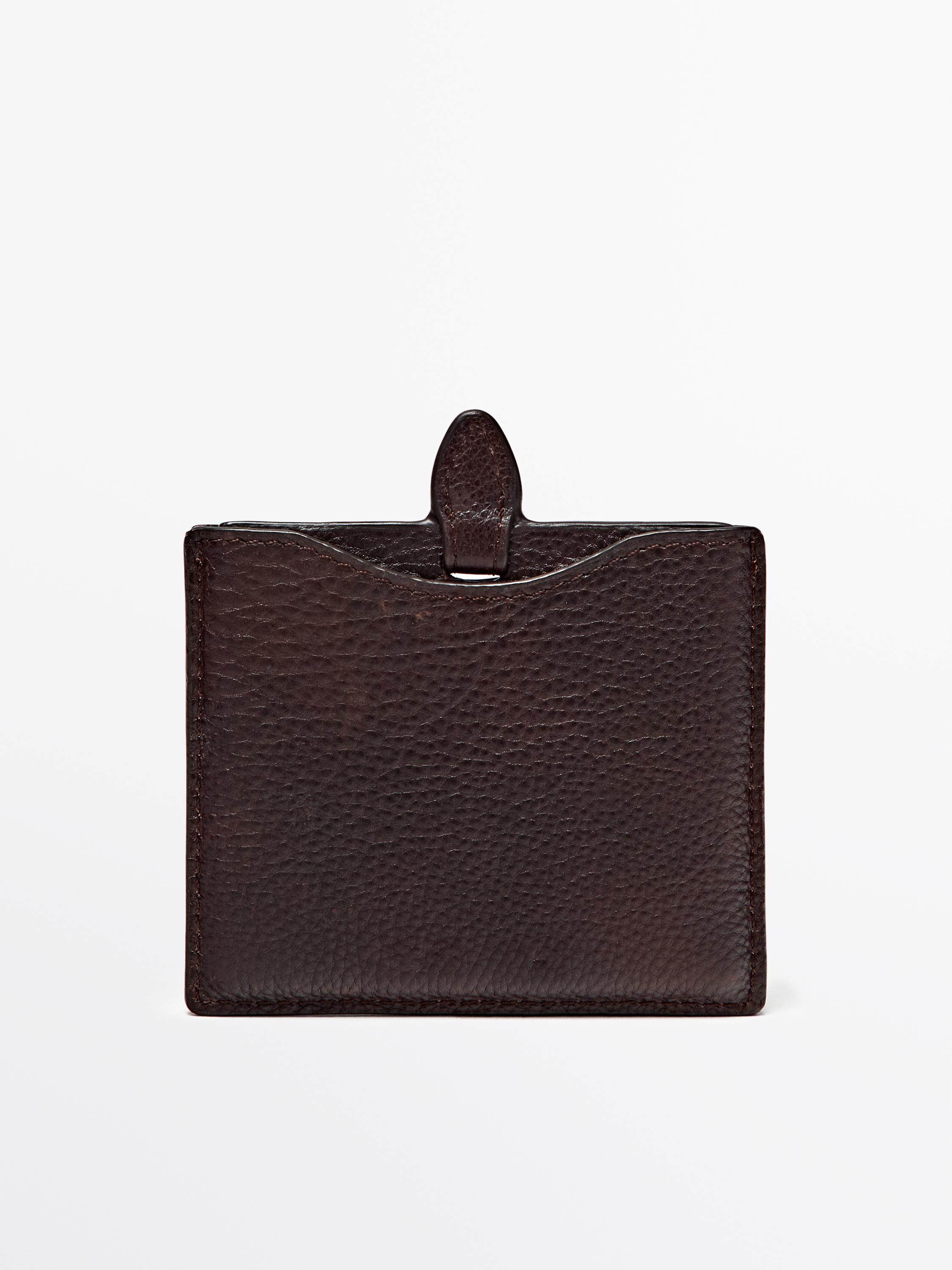 Front view of a chocolate purse with a granulated texture and a tab closure.