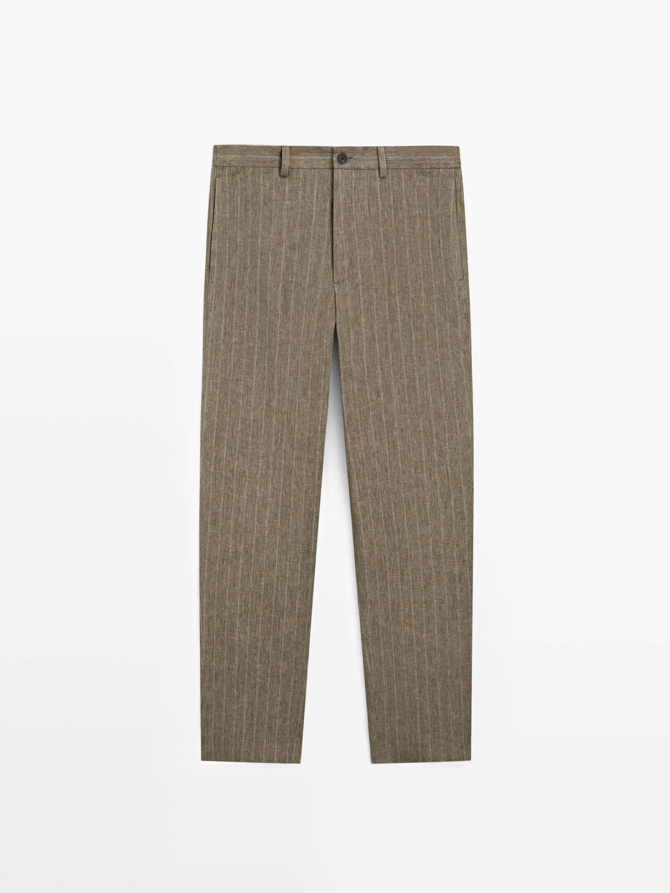 Vista frontal de pantalón verde con rayas verticales, cierre de botón y cremallera, trabillas para cinturón y bolsillos laterales.