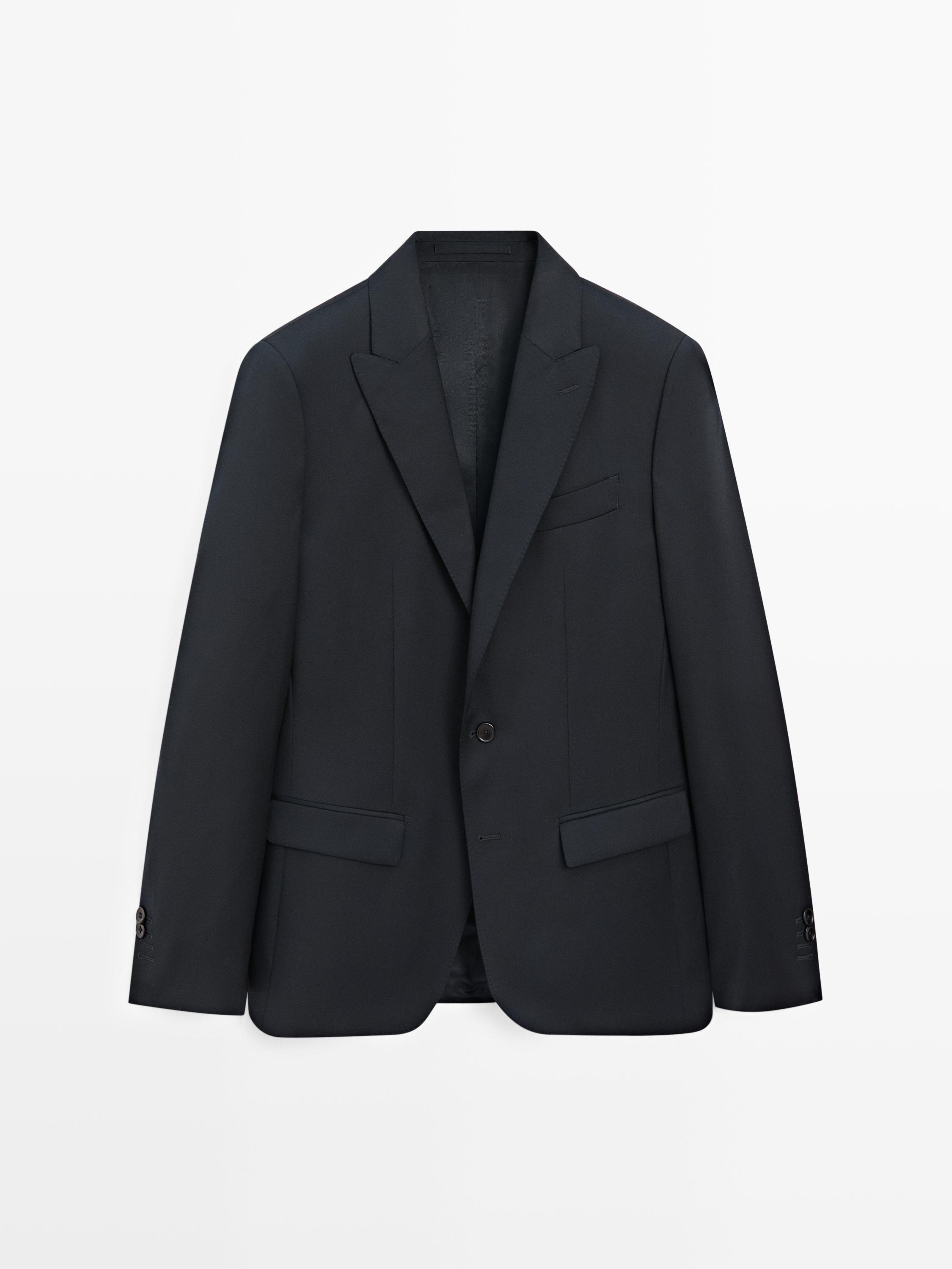 Μπροστινή όψη μπλε σκούρου σακακιού με μυτερό πέτο, κλείσιμο με ένα κουμπί και τσέπες με καπάκι.