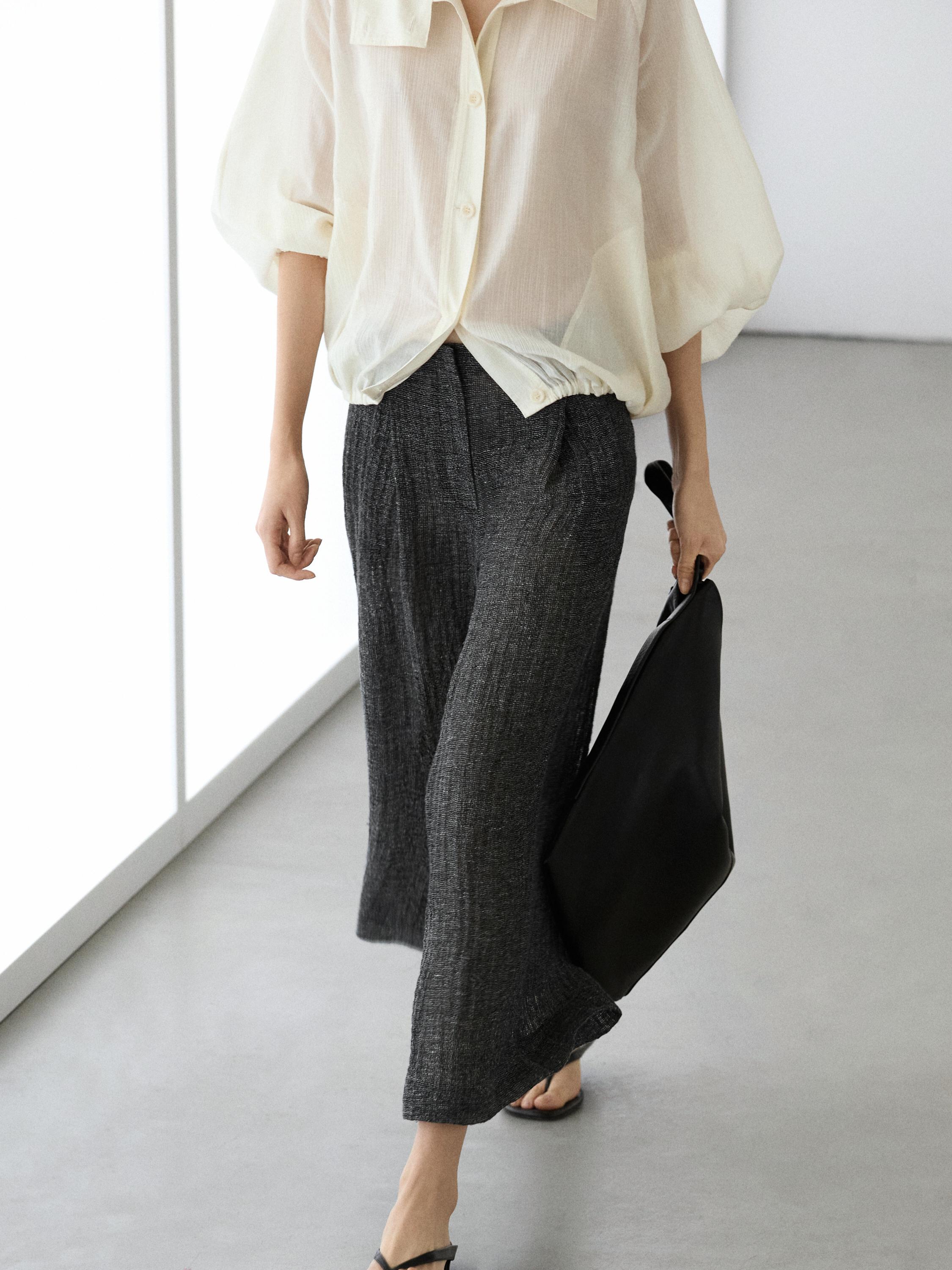 White button-down blouse and gray wide-leg pants set.