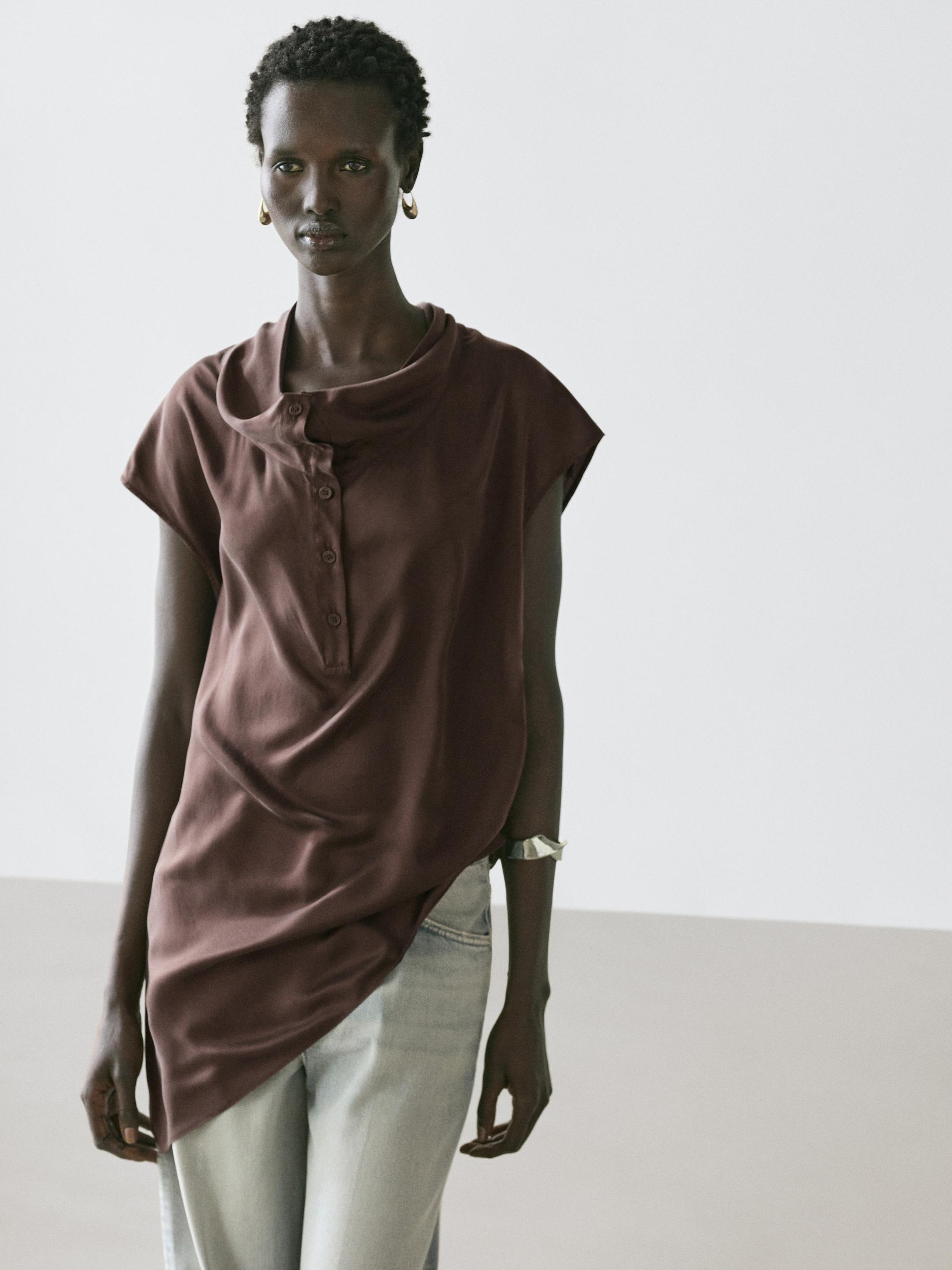 Ensemble avec top marron asymétrique drapé à boutonnage frontal et jean clair.