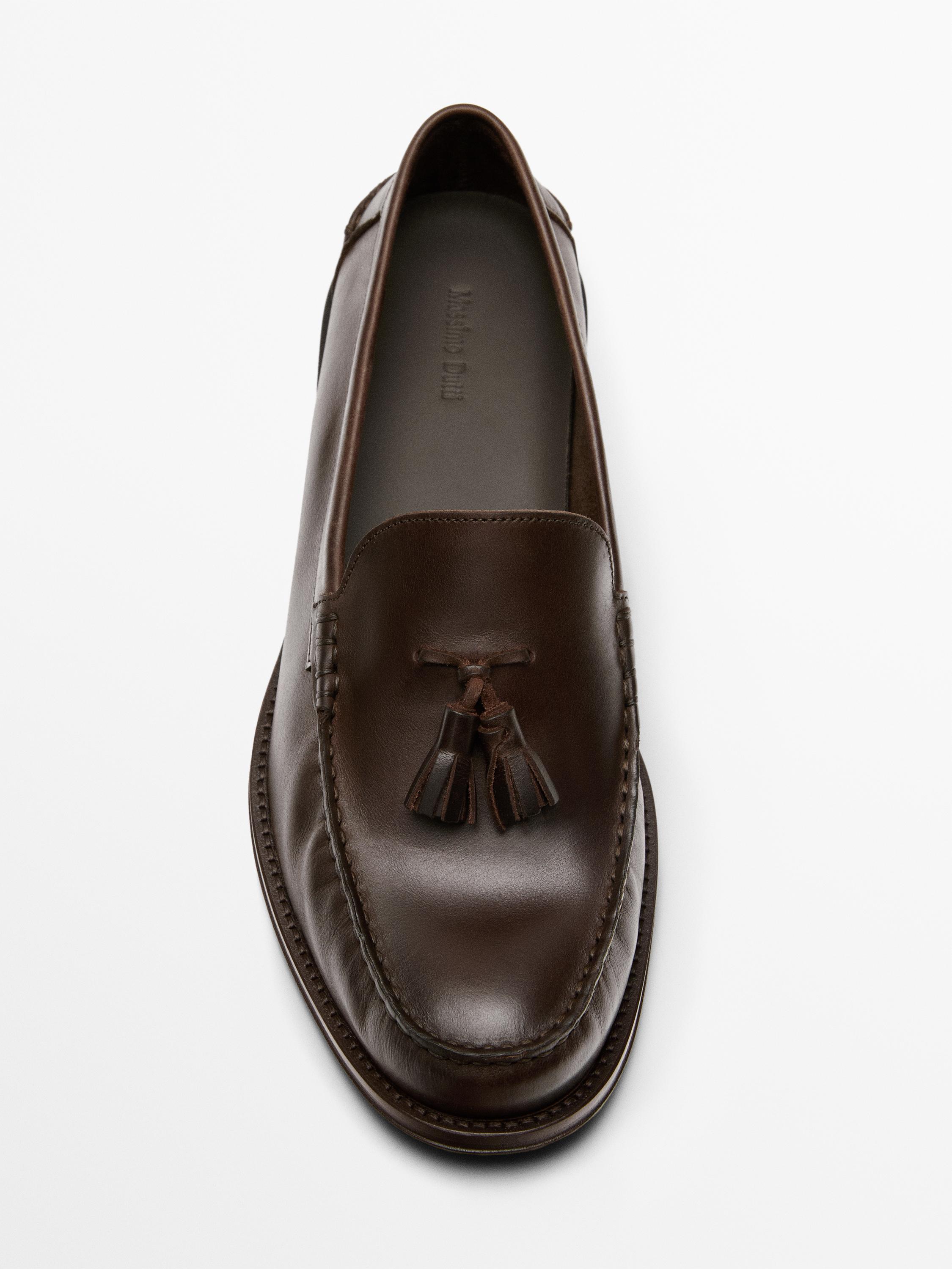 Top view of leather-colored loafer with decorative tassels on the vamp.