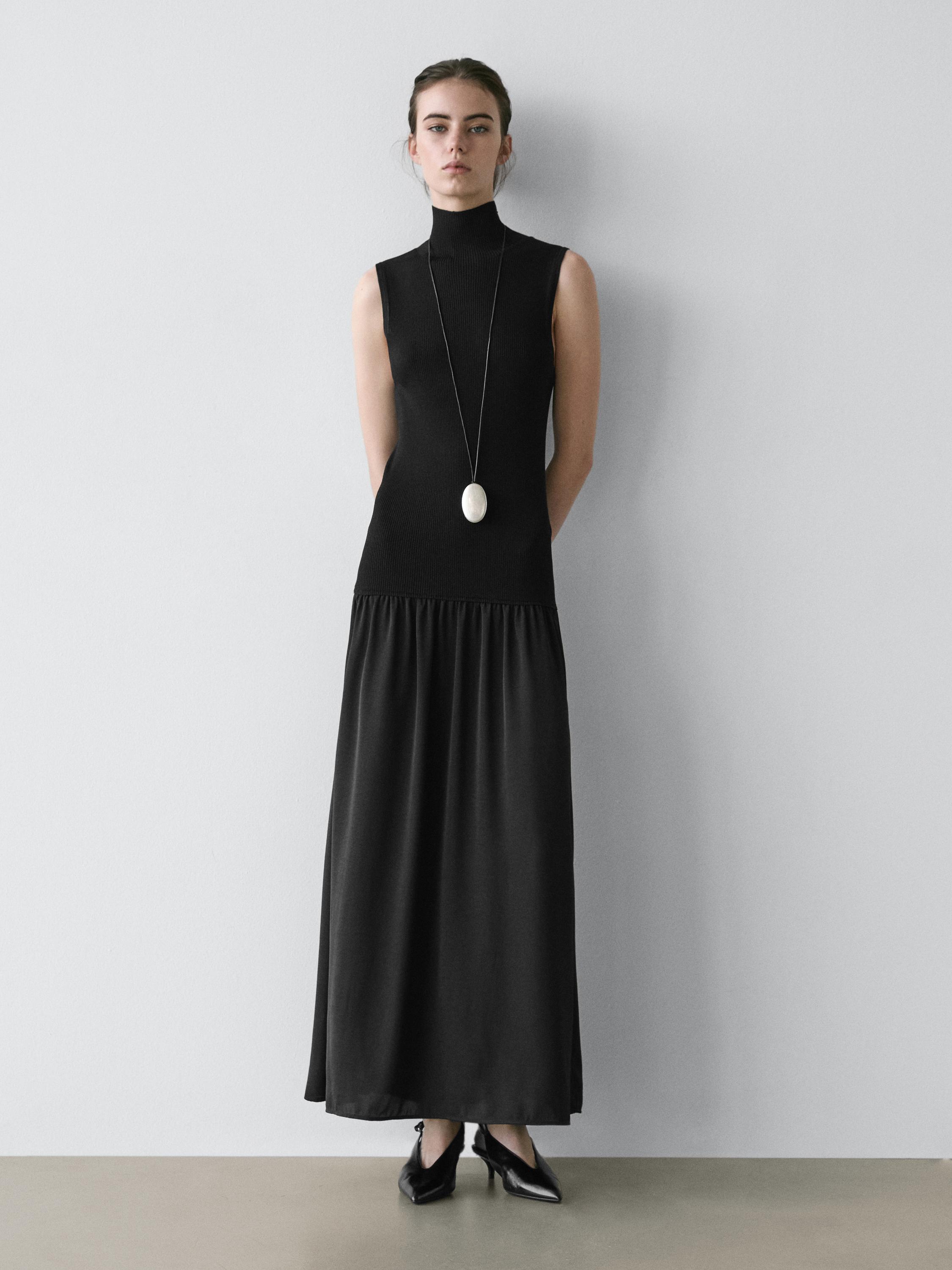 Black sleeveless knit midi dress set with a high neck and wide skirt.