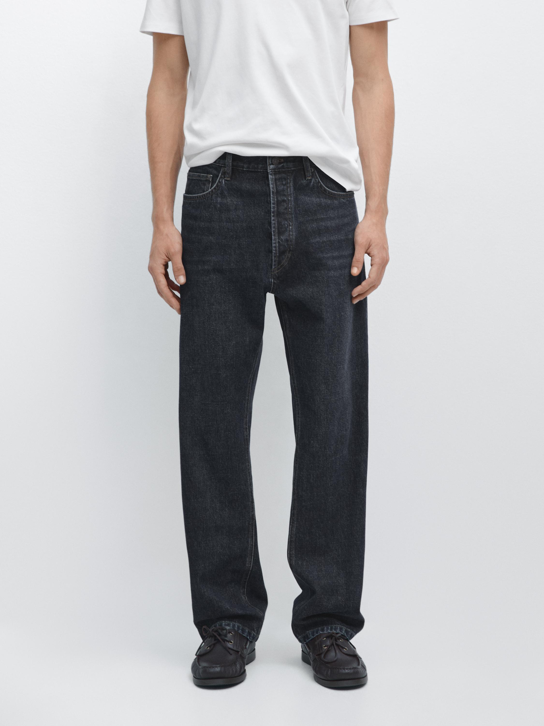 Niebieskie proste jeansy z widocznymi kieszeniami z przodu i z tyłu, połączone z białą koszulką.