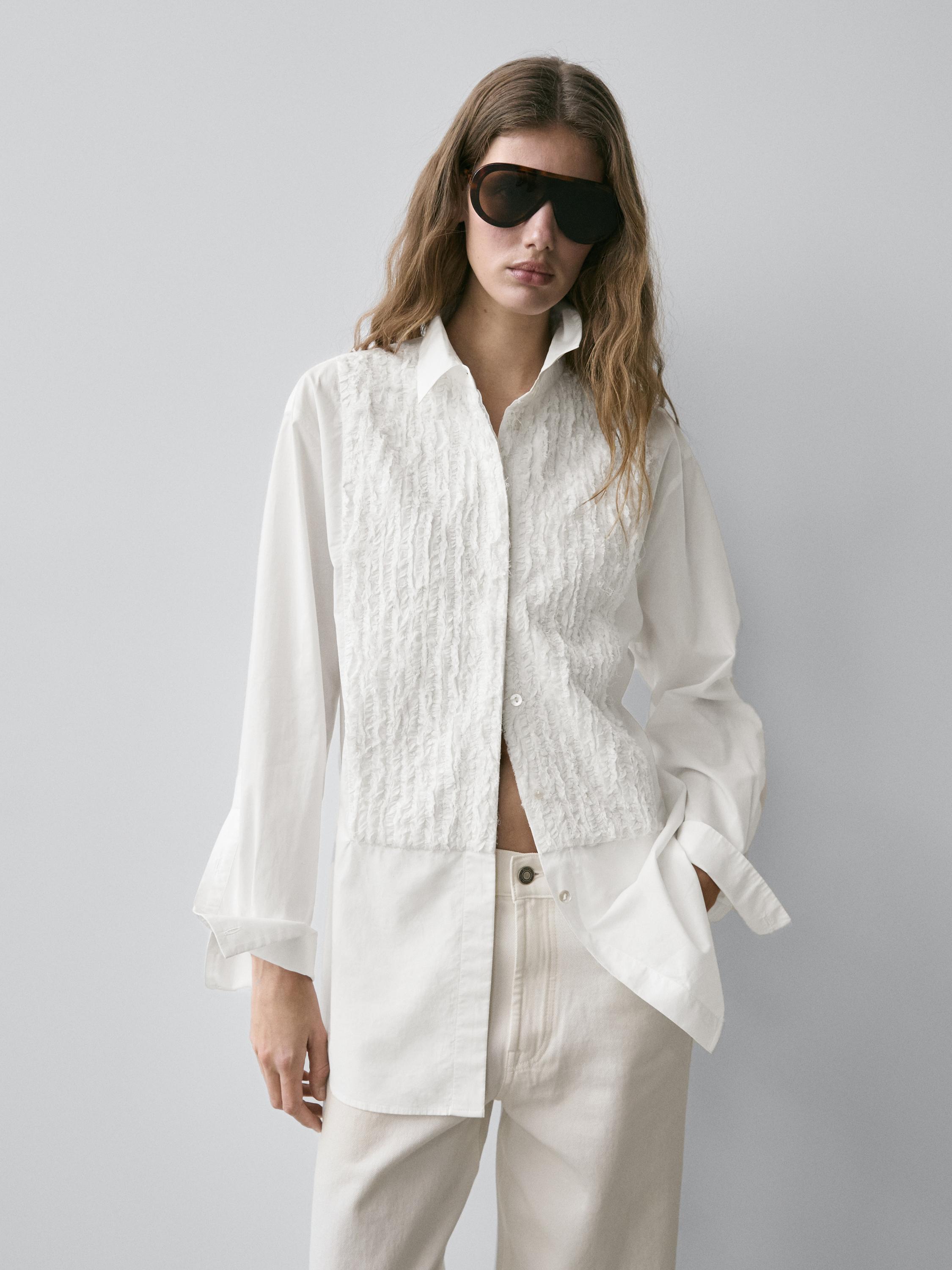 Komplet këmishë e bardhë me parzmore të qëndisur dhe pantallona të bardha.