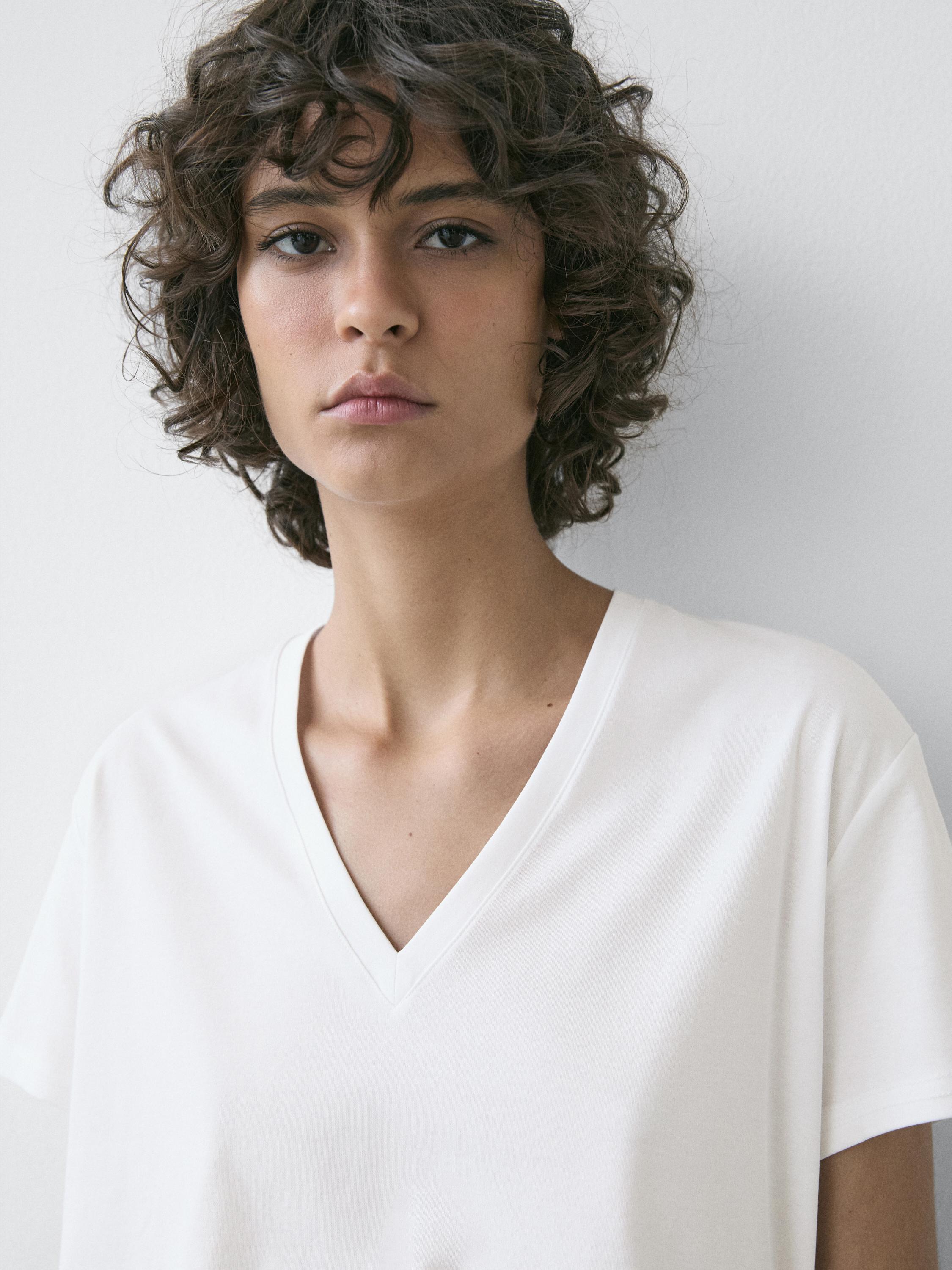Primer plano de playera blanca de manga corta con cuello en V.