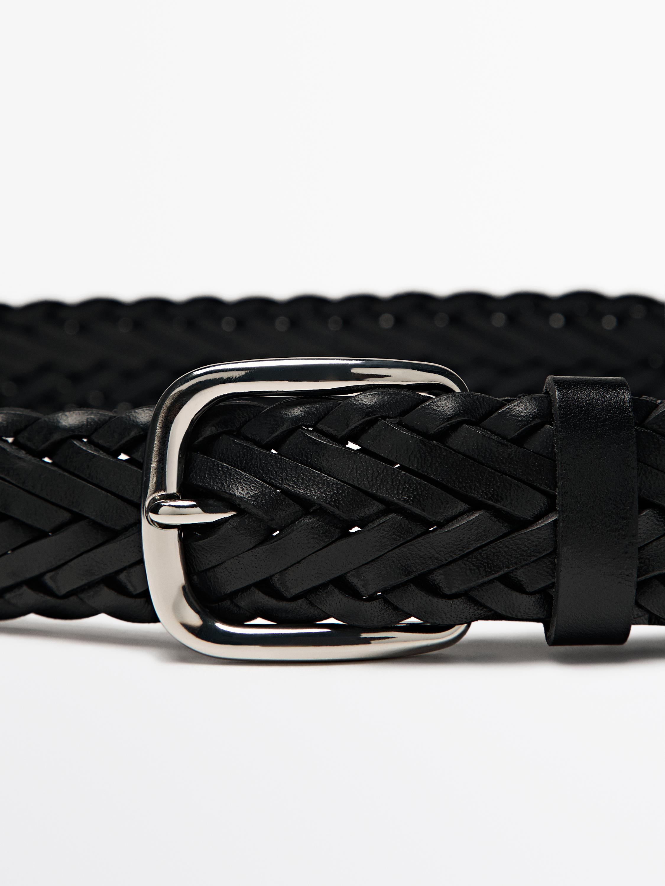 Detail ikat pinggang kepang hitam dengan gesper logam perak.