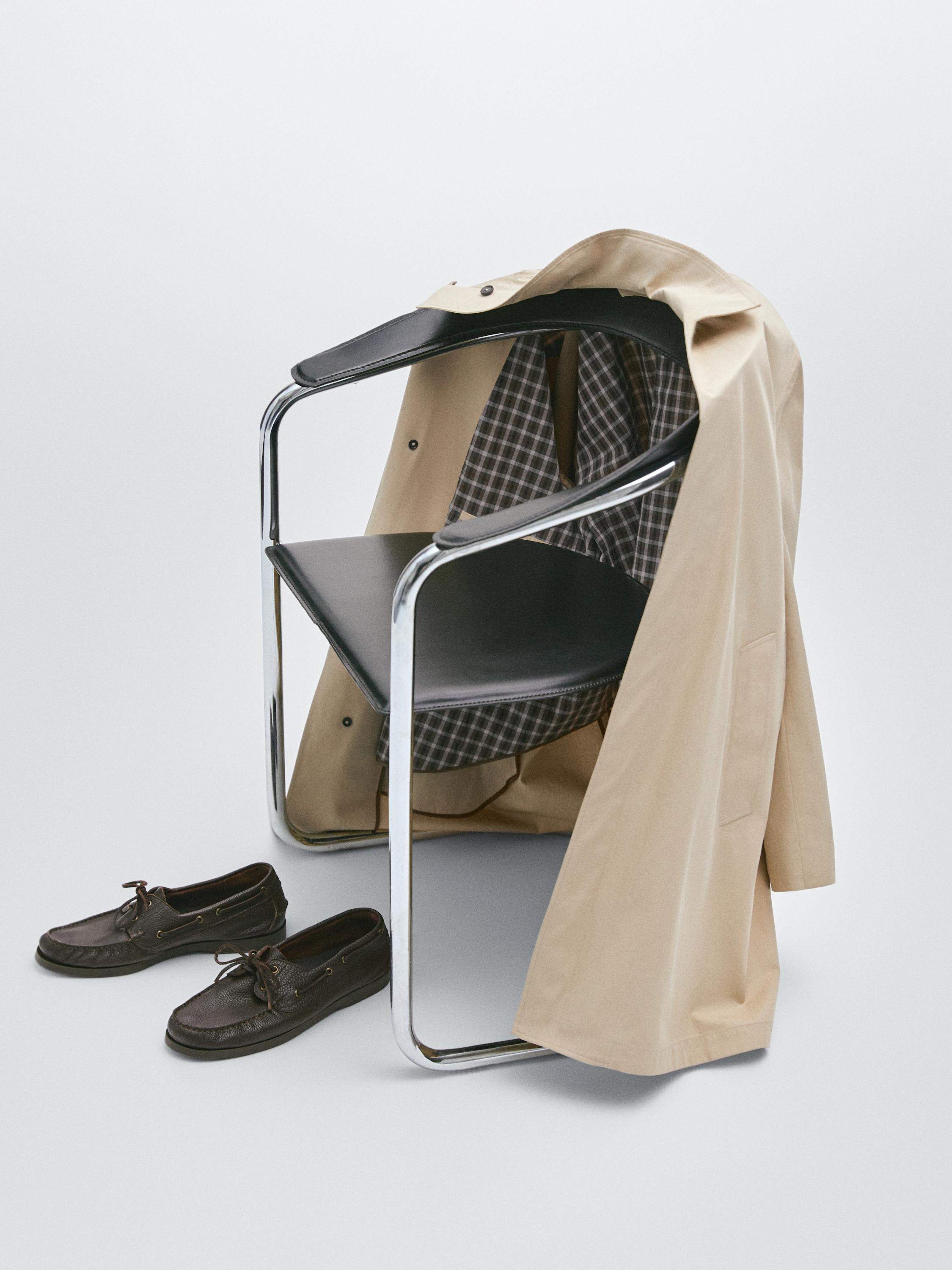 Vista frontal de gabardina bege com interior de xadrez.