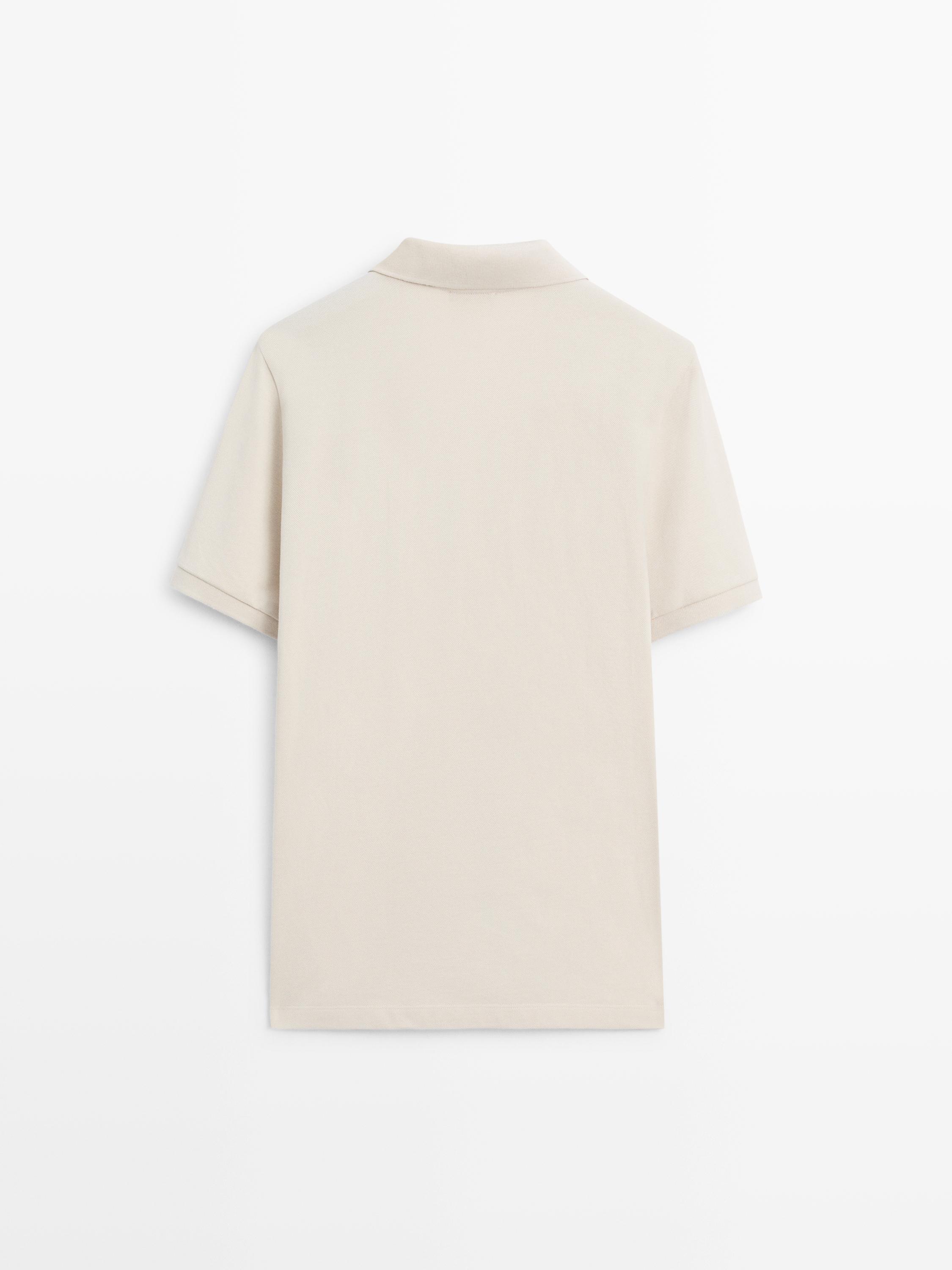 Vista posterior de polo piedra de manga corta con cuello clásico.